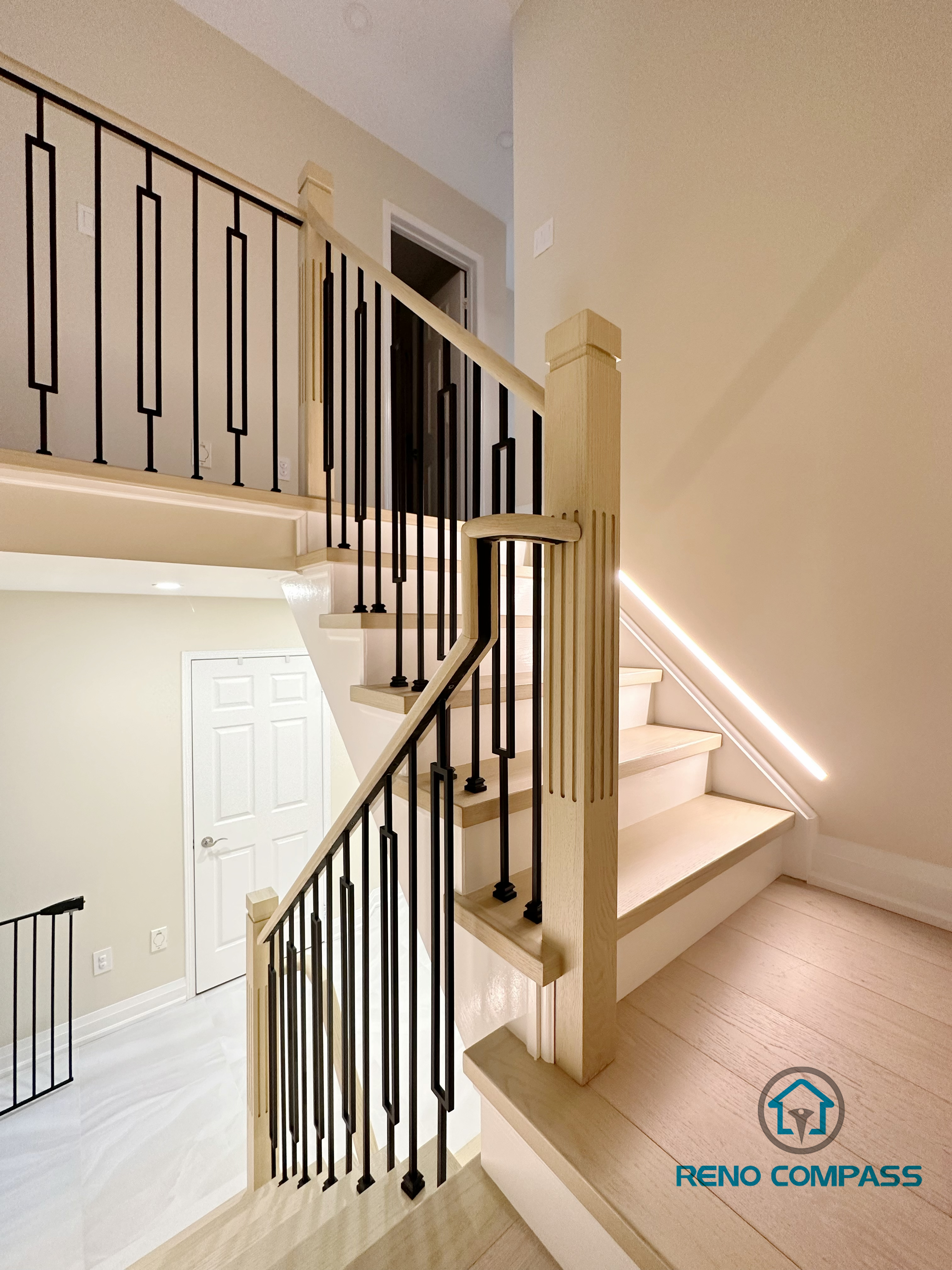 A stunning modern staircase renovation in Vaughan featuring custom  wooden steps, sleek glass railings, and integrated LED lighting for a contemporary and open feel.