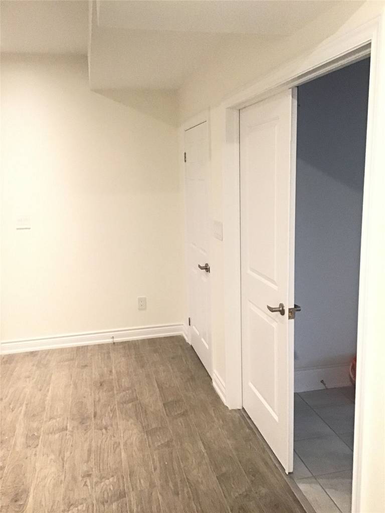 This Aurora basement renovation includes a clean and functional interior room layout with direct access to a finished bathroom. Featuring durable wood-style flooring, neutral wall tones, and modern doors, the space is designed for flexibility—ideal as a bedroom, rental unit, or private living area.
