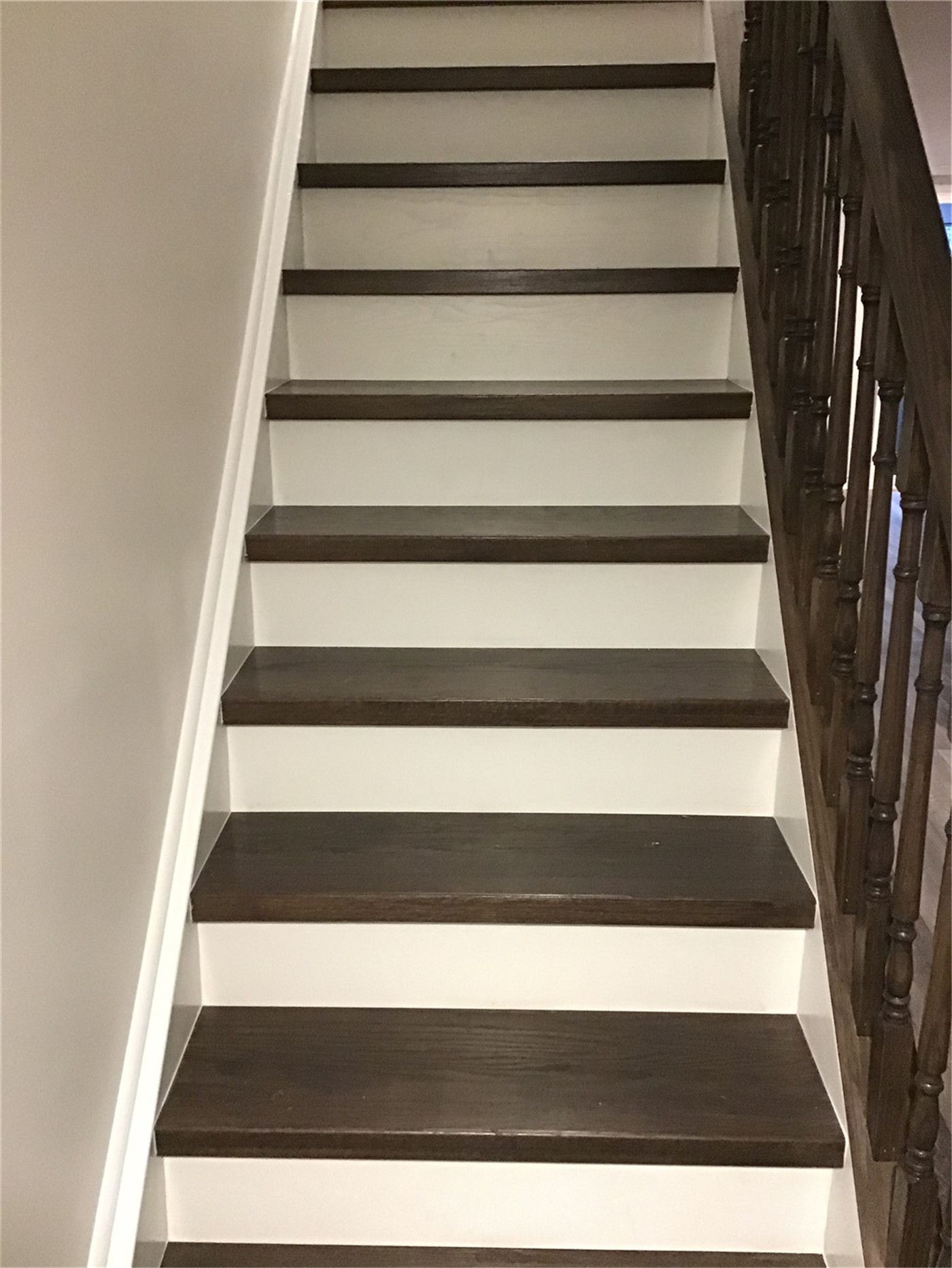 This Richmond Hill basement renovation includes an upgraded staircase featuring dark wood treads paired with clean white risers for a modern contrast look. The sturdy handrail and refined finish enhance both safety and aesthetics, making the transition between floors more stylish and functional. A great example of basement stair renovation in Richmond Hill.