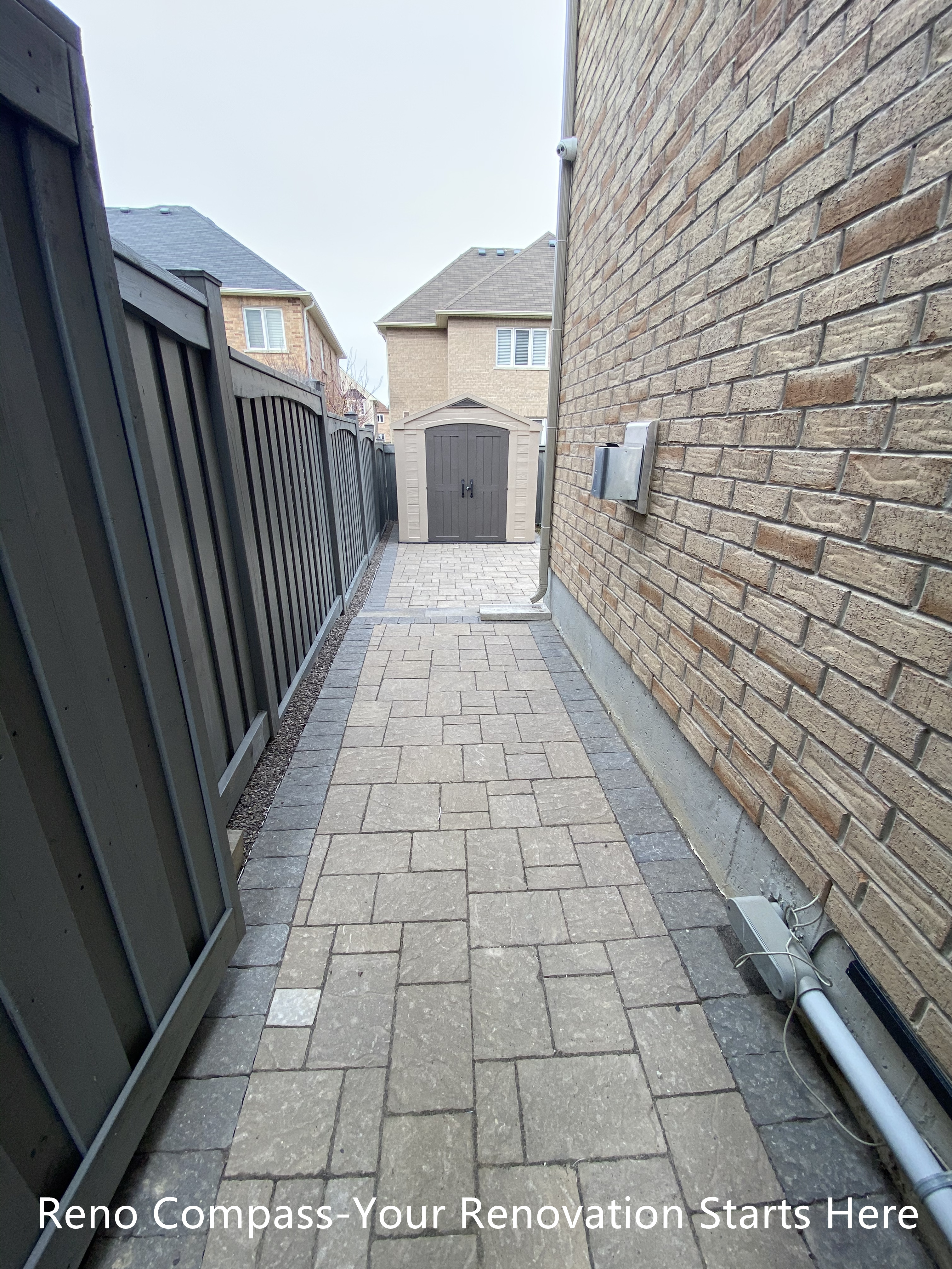 Side yard interlocking walkway renovation in Newmarket featuring a narrow passage paved with durable concrete pavers and clean edge restraints. The upgraded walkway improves drainage, accessibility, and long-term maintenance while creating a neat and functional transition between front and backyard spaces. Completed by a professional Toronto renovation company specializing in residential exterior renovations.