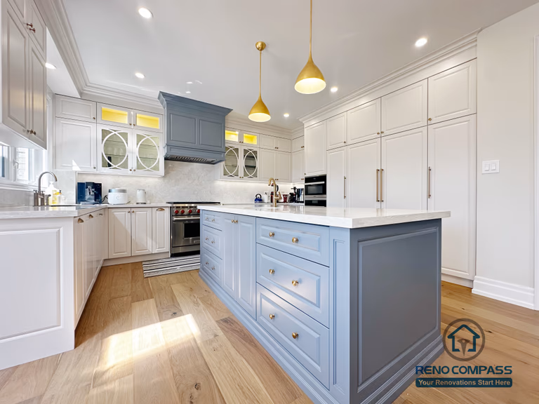 This North York kitchen renovation highlights a custom blue island with integrated drawers, full-height built-in cabinetry, and balanced recessed and pendant lighting. The layout maximizes storage efficiency while maintaining clean lines and visual symmetry, creating a refined and highly functional kitchen space designed and built by Reno Compass.