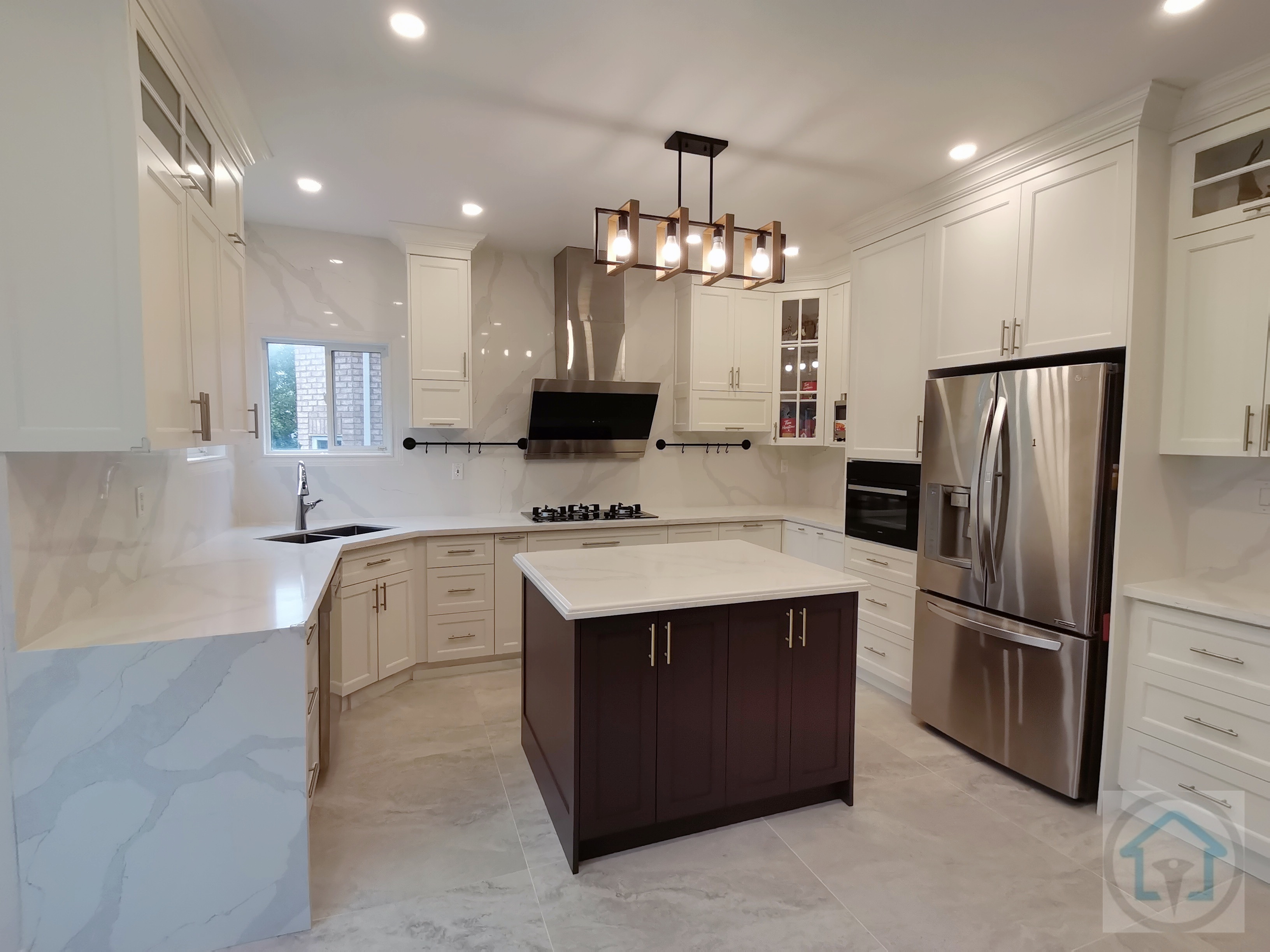 This bright white kitchen renovation showcases a clean, symmetrical layout centered around a statement dark-toned island. Full-height custom cabinetry, marble-look backsplash, and large-format floor tiles create a cohesive and upscale visual flow while enhancing light reflection throughout the space. The central island anchors the kitchen with added storage and prep space, making it ideal for both daily use and entertaining. Stainless steel appliances, integrated lighting, and a modern range hood complete the design with a balance of functionality and elegance. Completed by an experienced Toronto renovation company, this kitchen renovation highlights thoughtful planning, refined material selection, and long-term livability for modern family homes.