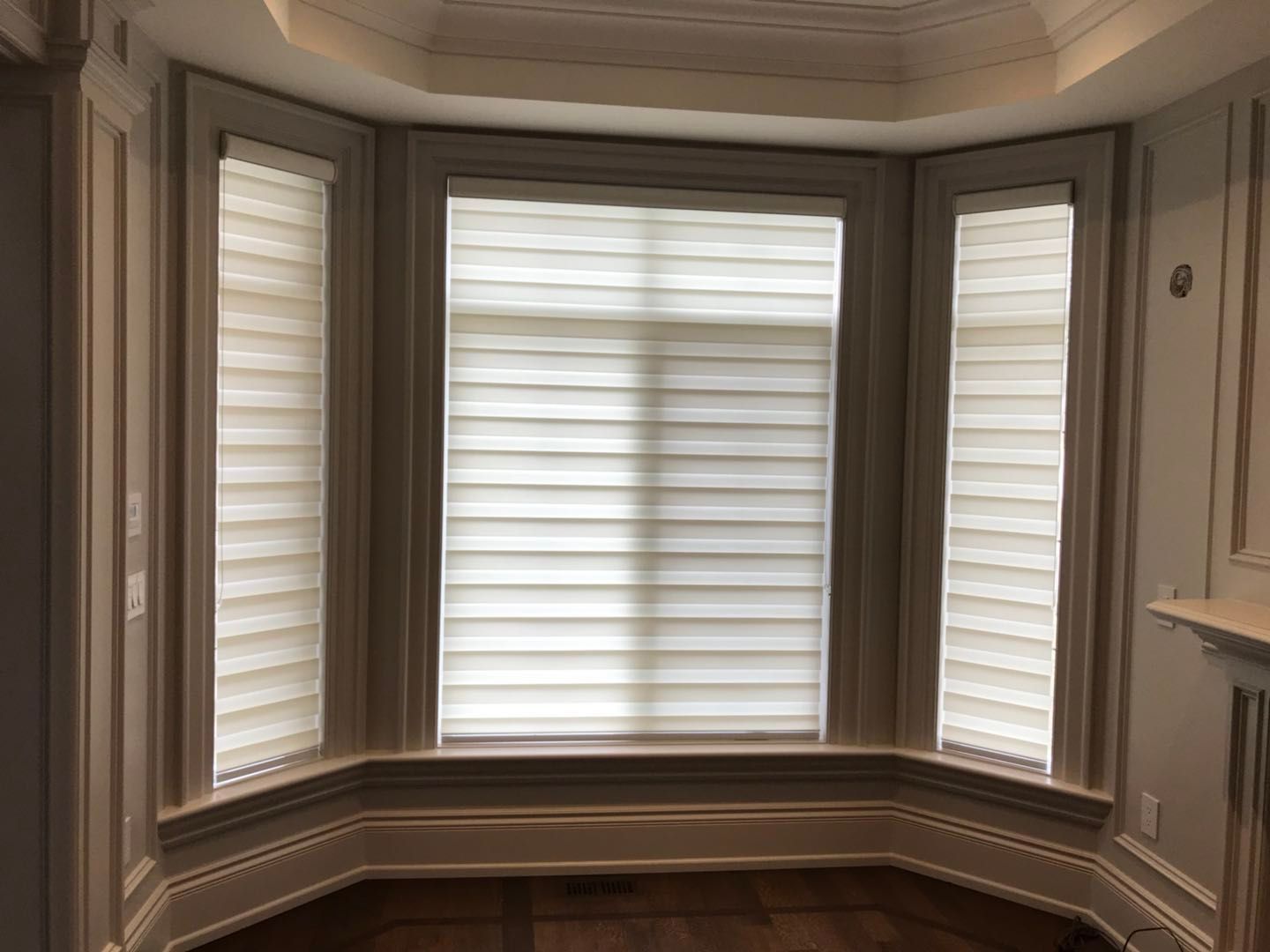 Custom zebra blinds installation in Toronto dining room by professional Toronto renovation company Reno Compass Inc. Featuring dual-layer light filtering shades, clean white window trim, modern chandelier lighting, and elegant wall panel detailing. This window treatment upgrade enhances privacy, natural light control, and interior aesthetics with a sleek and contemporary finish.