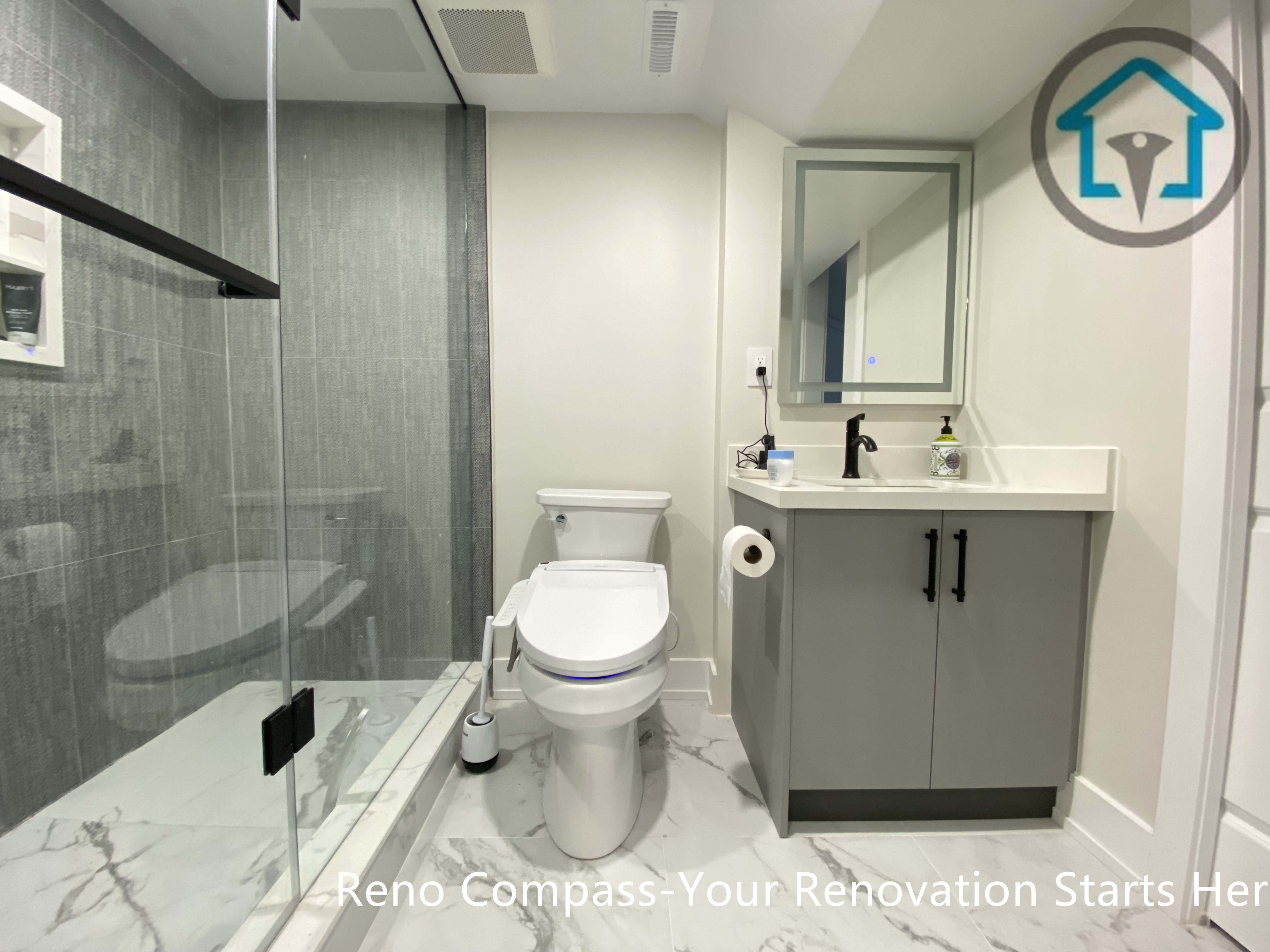 This Stouffville basement bathroom renovation features a walk-in glass shower with large-format tile, a modern vanity with quartz countertop, matte black fixtures, and marble-look floor tiles. Designed for durability and daily comfort, this clean and functional basement bathroom was completed by Reno Compass Inc.