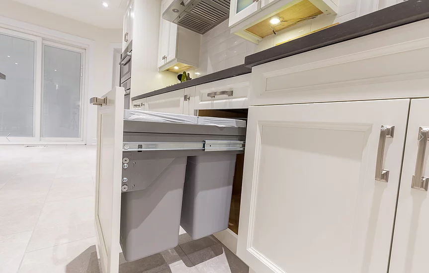 A custom pull-out waste bin system integrated into the kitchen cabinetry for our Vaughan full house renovation. This sleek and functional design keeps the kitchen clean, organized, and efficient, highlighting the blend of modern convenience and craftsmanship.