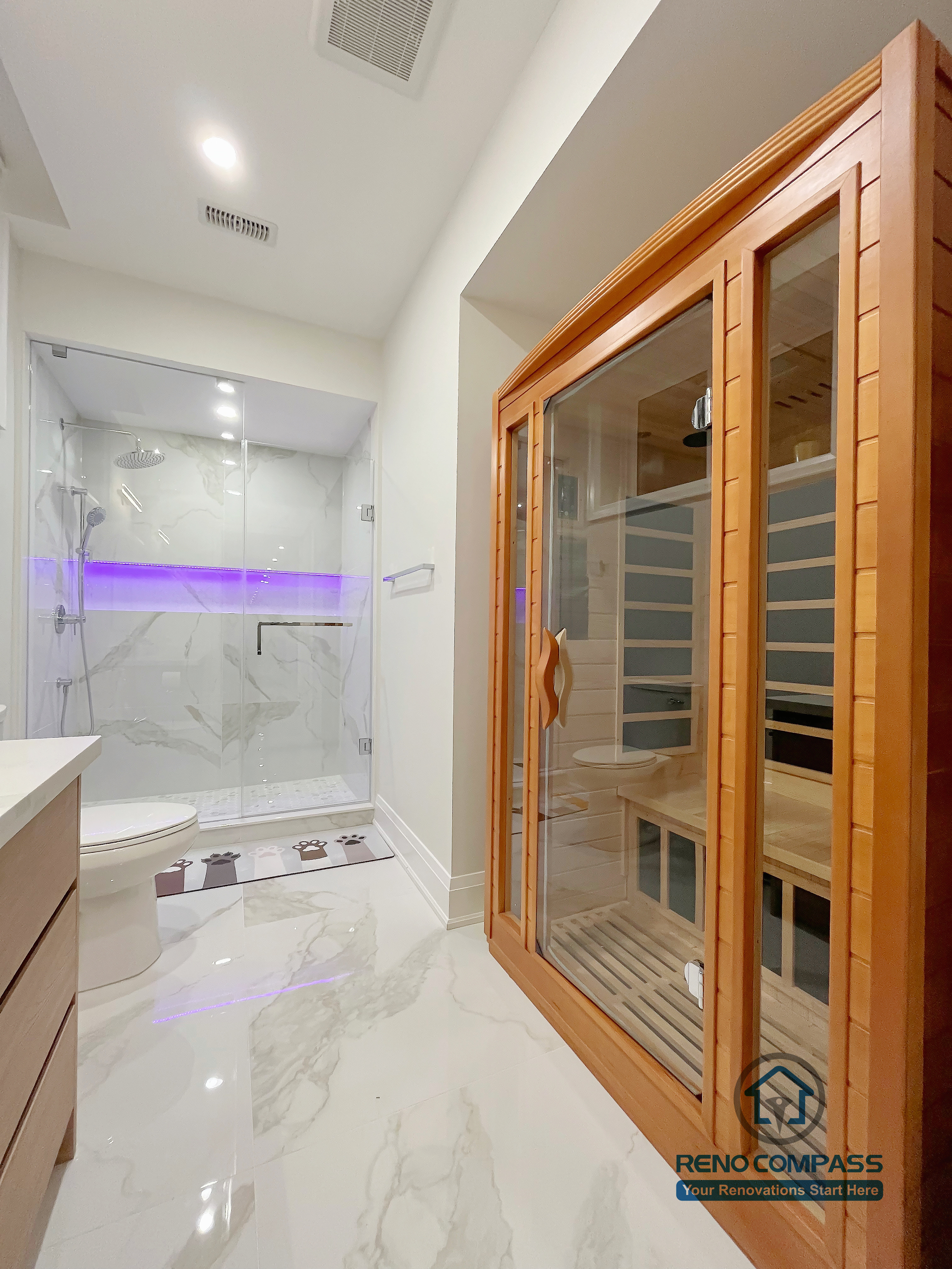Basement bathroom renovation in Newmarket featuring a glass shower enclosure, marble-look tile flooring, modern fixtures, and a built-in sauna, creating a clean and spa-inspired wellness space.