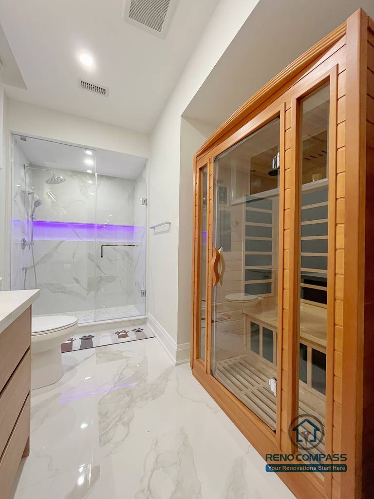Basement bathroom renovation in Newmarket featuring a glass shower enclosure, marble-look tile flooring, modern fixtures, and a built-in sauna, creating a clean and spa-inspired wellness space.