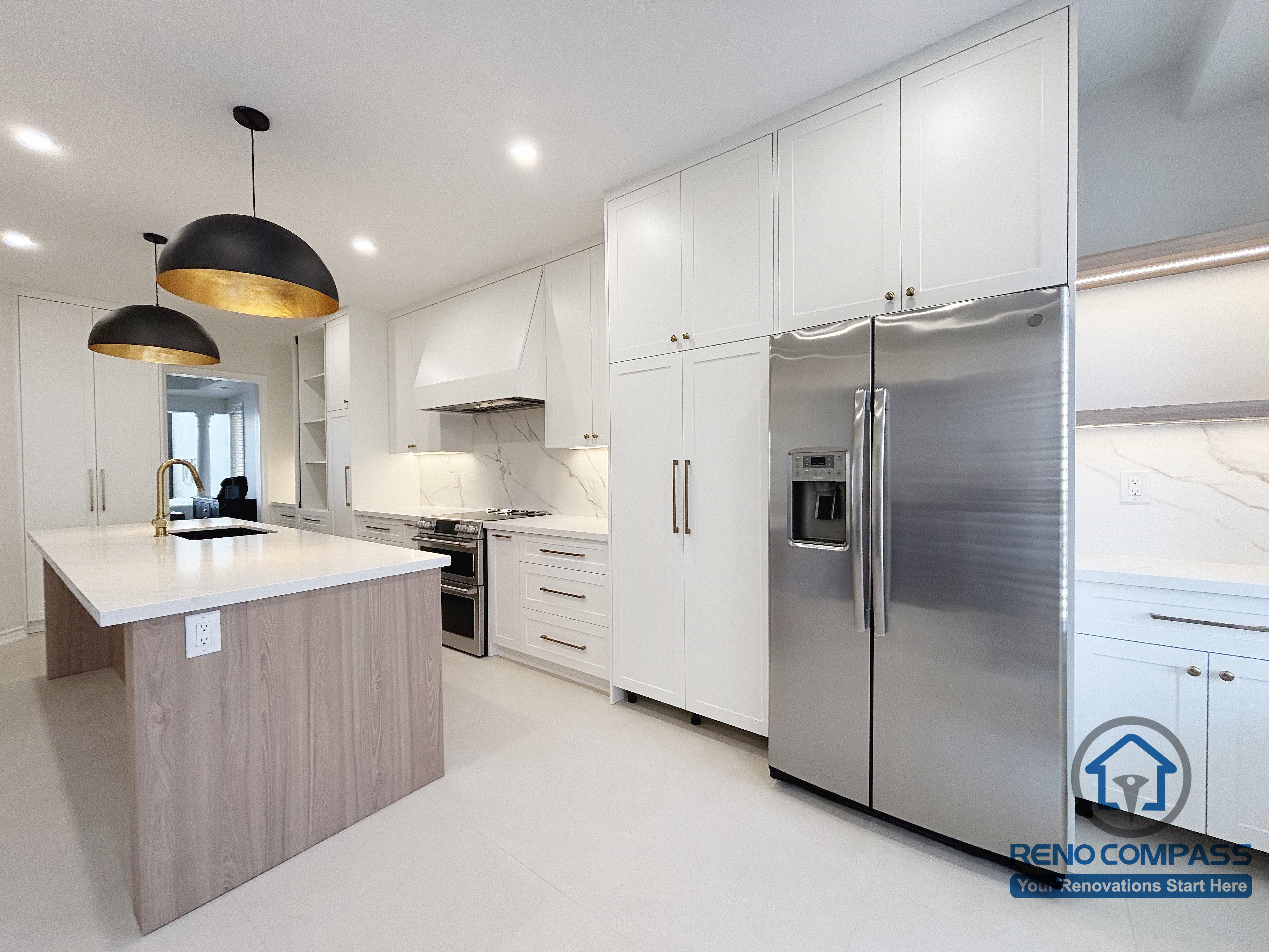 This Oakville kitchen renovation presents a clear view of the integrated appliance wall paired with a central island, emphasizing proportion, circulation, and functional balance. Full-height cabinetry conceals storage and appliances for a clean, uninterrupted appearance, while the island anchors the space for preparation and everyday interaction. Consistent finishes and restrained detailing help maintain visual order throughout the kitchen. Completed by Reno Compass, this design reflects a practical and well-structured approach to modern Oakville kitchen renovation.