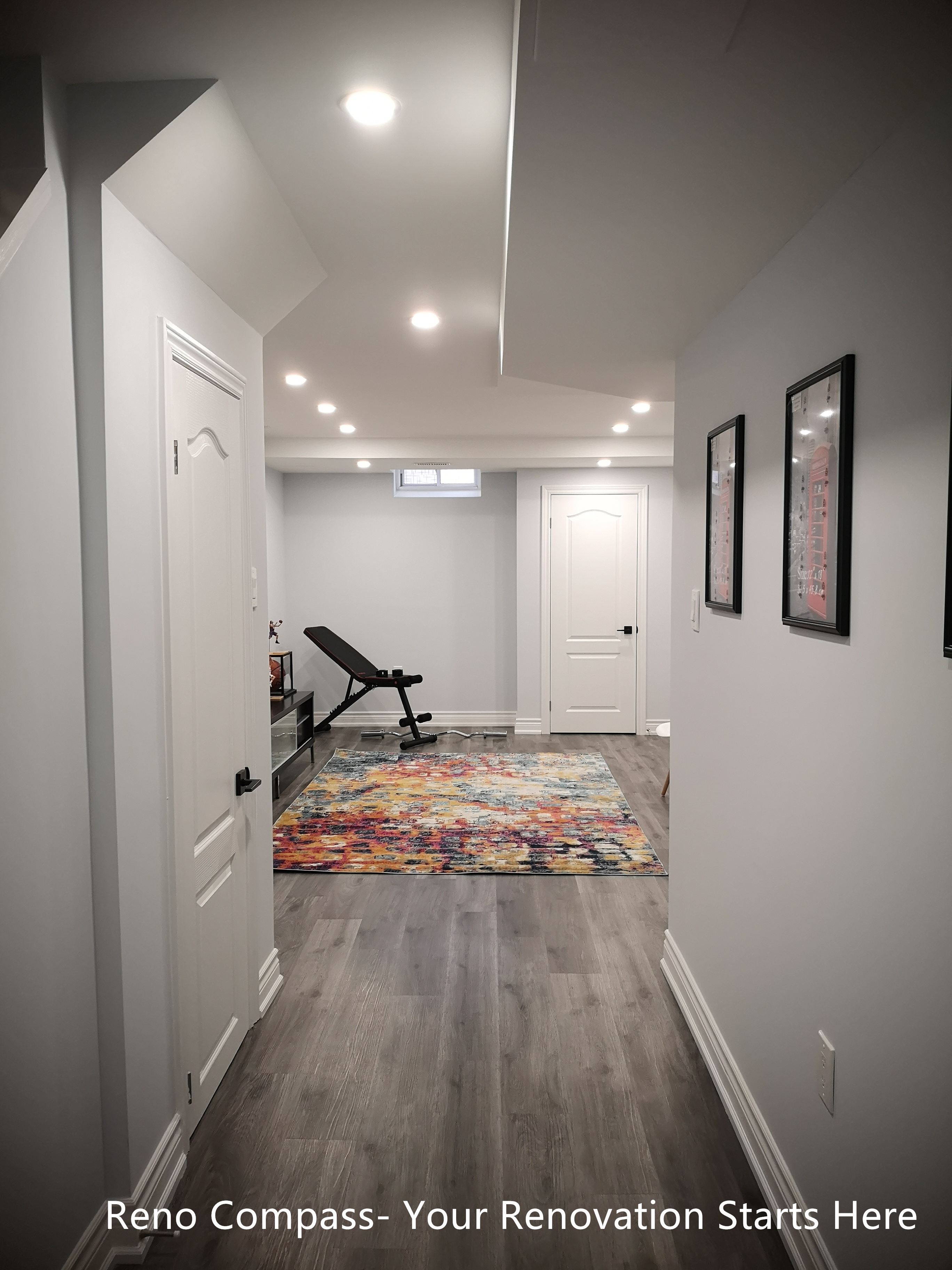This Whitby basement renovation features a finished hallway that connects the staircase to the main basement living and recreation area. Wood-look flooring runs continuously throughout the space, enhancing visual flow and consistency. Recessed ceiling lights provide even illumination, while clean wall finishes and minimal trim details create a modern, uncluttered appearance. The hallway layout improves circulation and accessibility, making the basement suitable for multi-purpose use such as a home gym, entertainment area, or additional living space.