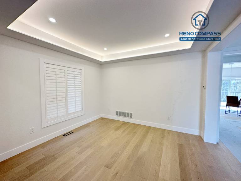 Spacious living area in a Richmond Hill home featuring light-tone hardwood flooring, a modern tray ceiling with recessed lighting, and large windows that enhance brightness and a clean, contemporary interior.
