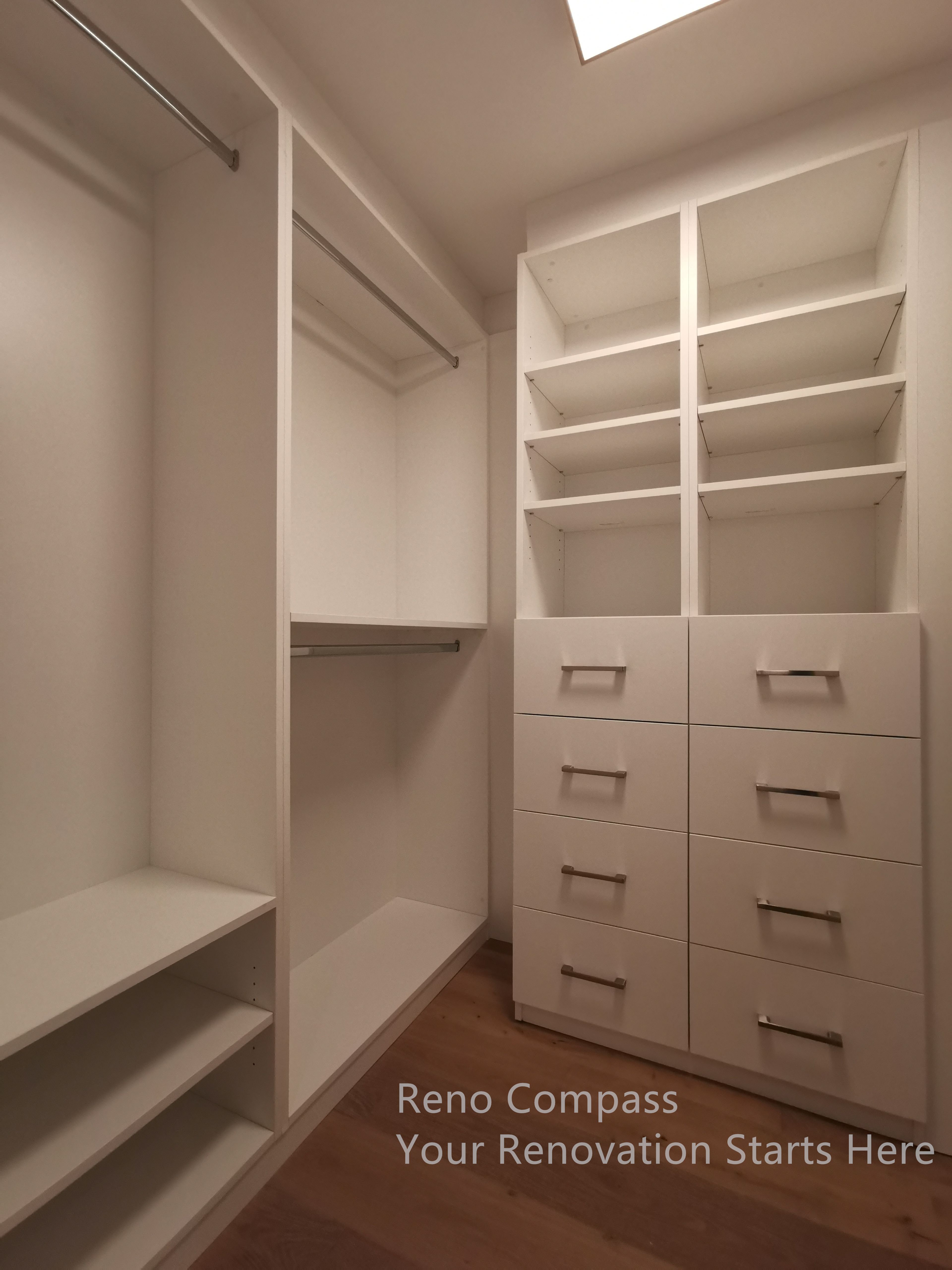 This image features a custom walk-in closet completed as part of a Markham interior renovation. The built-in storage system includes open shelving, full-height hanging sections, and multiple drawer units designed to maximize organization and accessibility. Clean white cabinetry paired with warm wood flooring creates a bright and functional space, offering long-term durability and efficient storage tailored to everyday living.