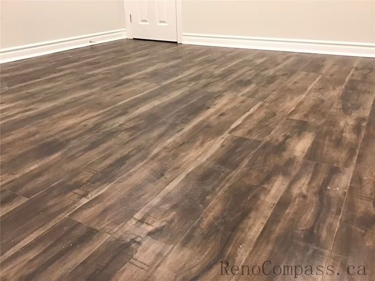 High-quality laminate flooring installation in this Whitby basement renovation, featuring rich wood-tone finishes that add warmth and durability to the space. The moisture-resistant material is ideal for basement environments, providing both style and long-term performance. Completed by an experienced Toronto renovation company, this project highlights precise flooring installation and attention to detail