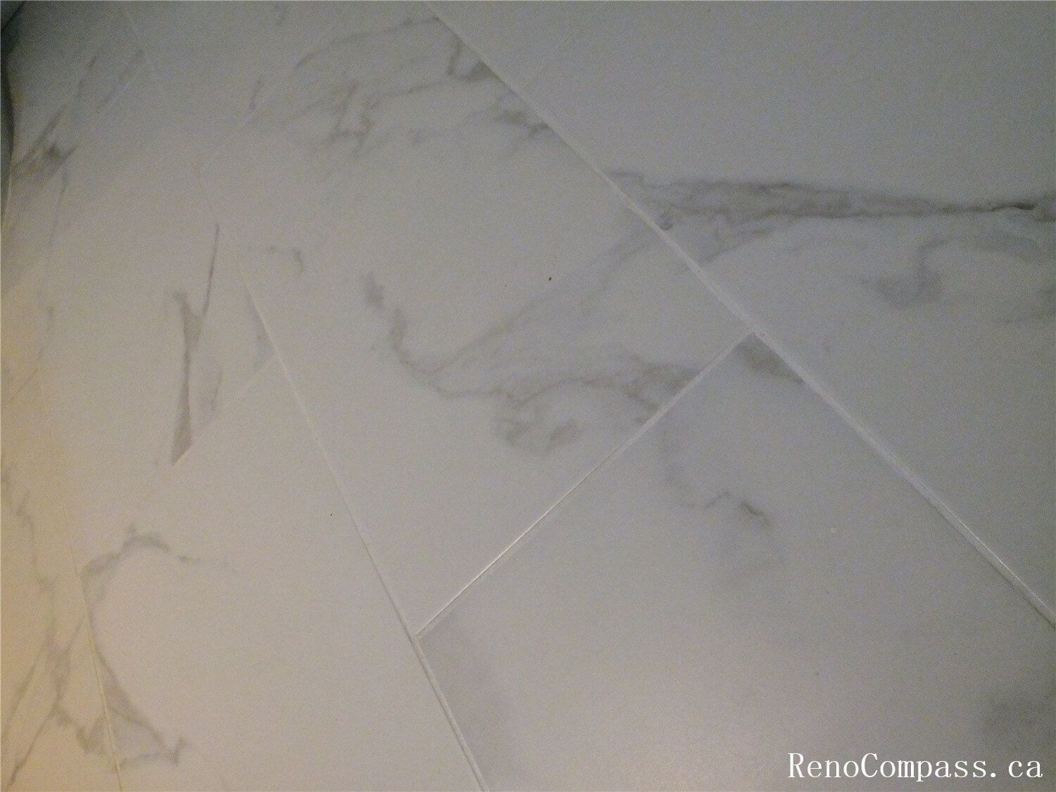 Close-up view of marble-look porcelain floor tiles installed in the basement bathroom during this Ajax basement renovation. The large-format tiles with soft grey veining create a clean, modern appearance while providing durability and moisture resistance—ideal for basement environments. Installed by a professional Toronto Renovation Company, this flooring upgrade enhances both the elegance and practicality of the renovated bathroom space.