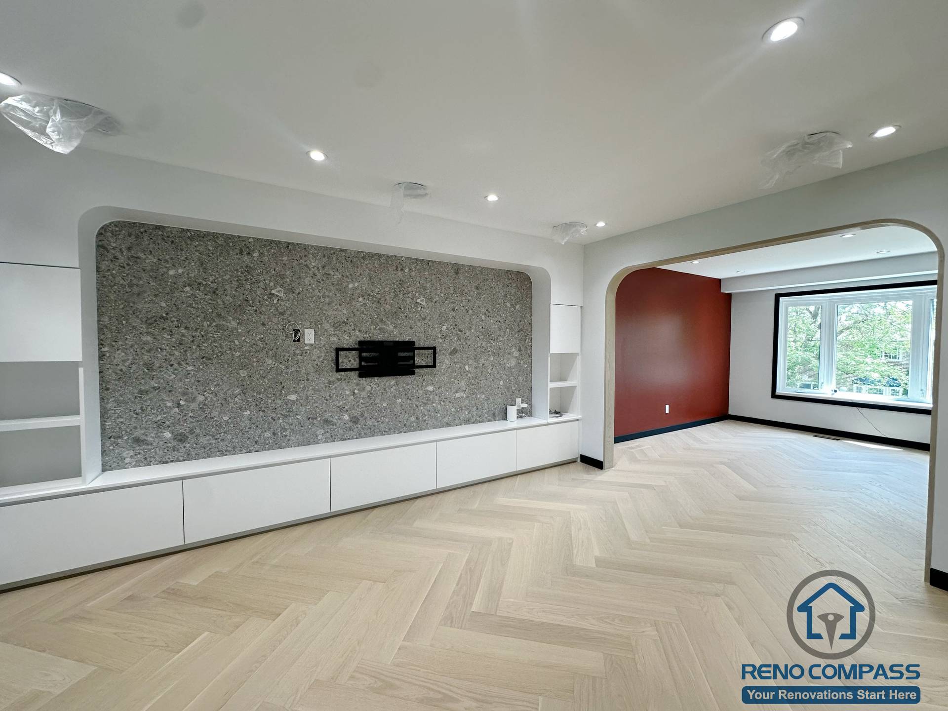This is a modern living room renovation project located in Richmond Hill, featuring light herringbone flooring, a stone TV accent wall, and custom built-in cabinetry.
The clean and minimal layout creates a bright, open, and functional living space, perfect for modern family living.