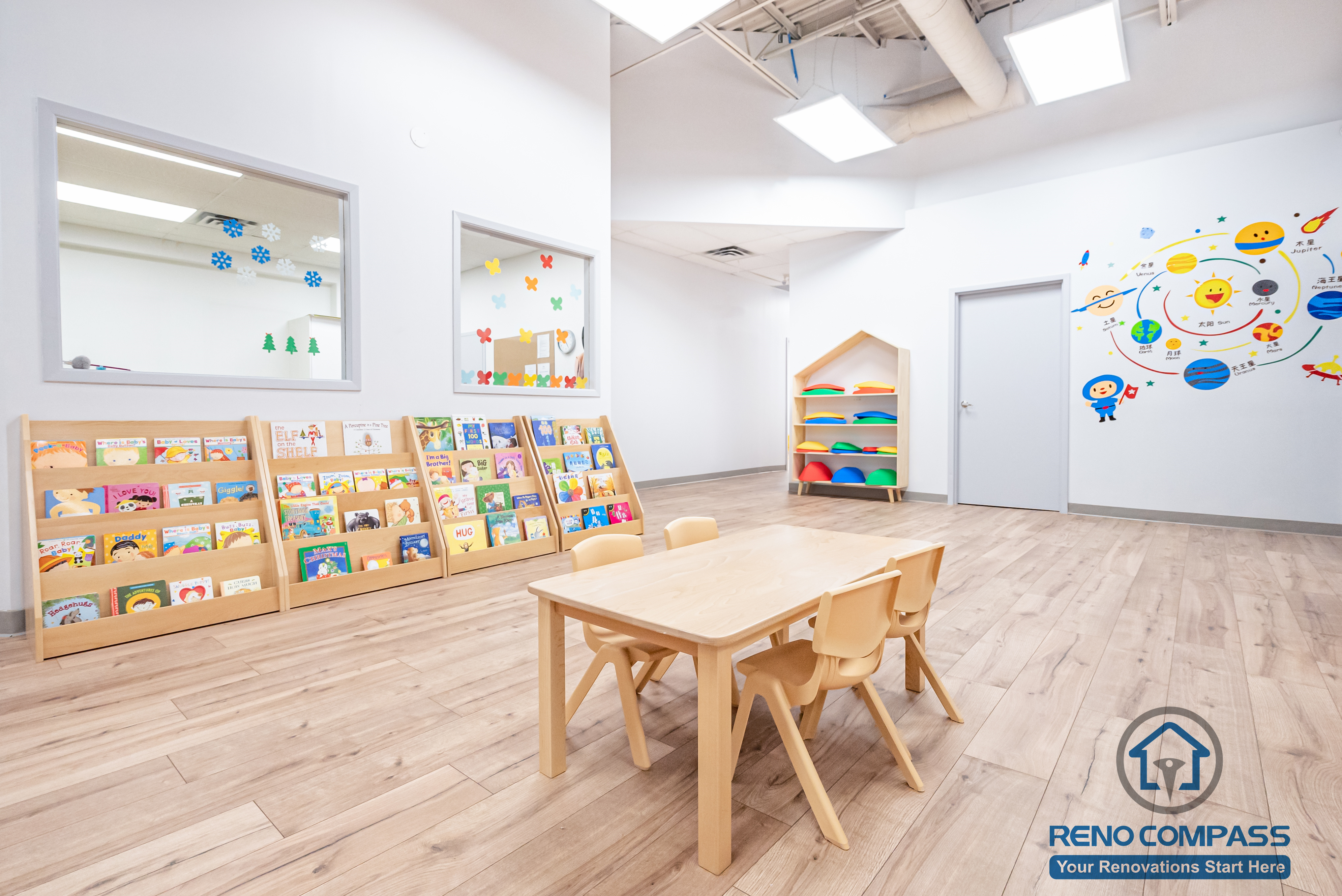 This Markham daycare renovation features a dedicated reading and learning corner designed to support early literacy, quiet activities, and small-group learning. Low-height book displays allow children to independently select reading materials, encouraging engagement and self-guided exploration. Child-sized tables and chairs provide a comfortable setting for group activities and creative play. Durable, easy-to-clean flooring and bright overhead lighting enhance safety and long-term maintenance. Completed by a Toronto renovation company, Reno Compass Inc., this daycare interior renovation reflects a child-centered design approach that balances educational needs, safety standards, and functional space planning for modern childcare environments.