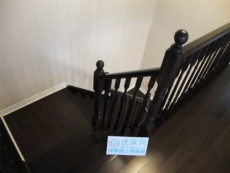 Dark hardwood staircase and flooring renovation in a Toronto home, featuring modern wood stair railing and matching hardwood floors as part of a professional interior renovation project by a Toronto renovation company.