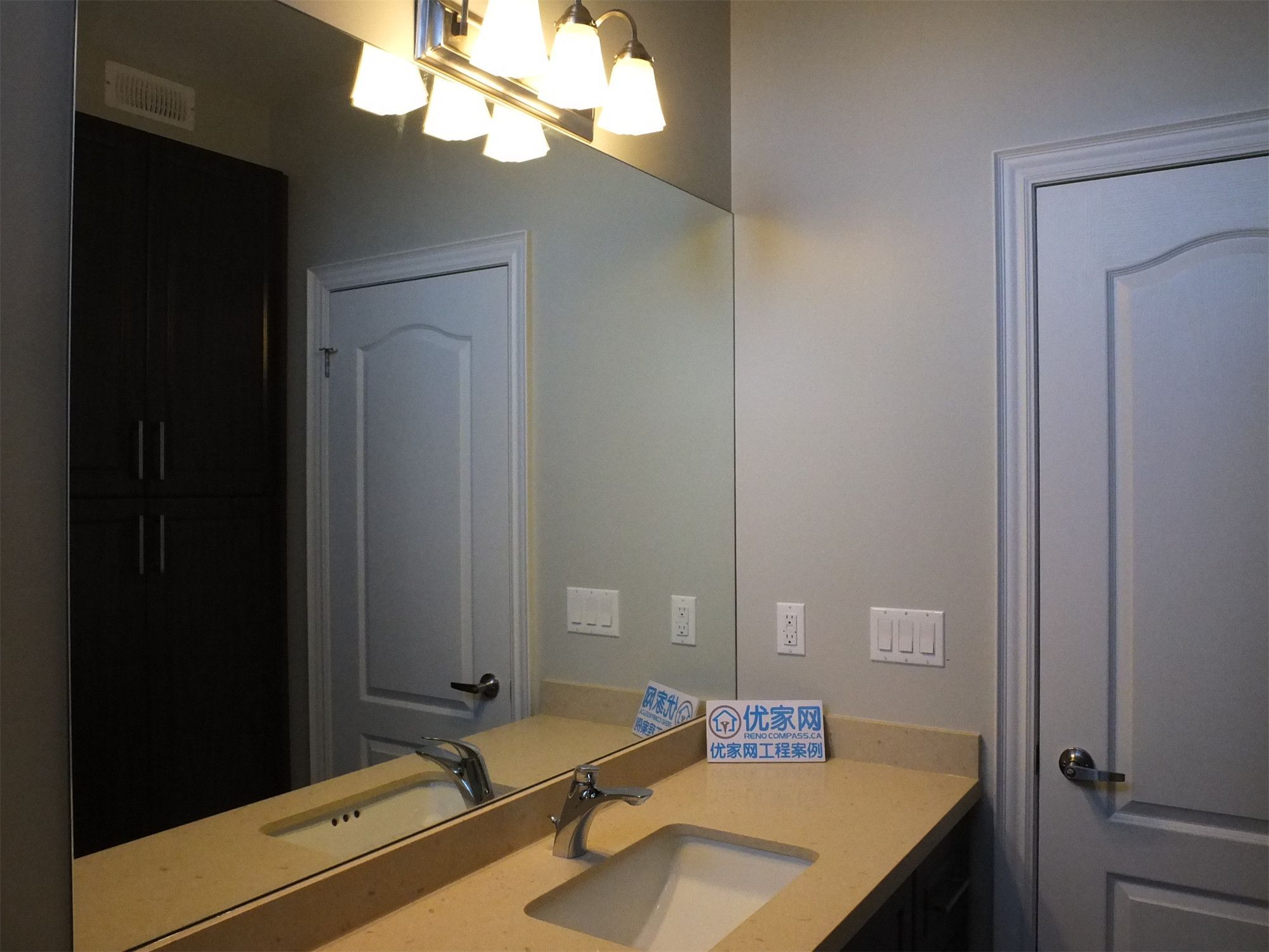 This Richmond Hill basement renovation features a modern bathroom vanity with a quartz countertop, large mirror, and stylish overhead lighting. The clean design and warm lighting enhance both functionality and aesthetics, creating a bright and polished bathroom space.