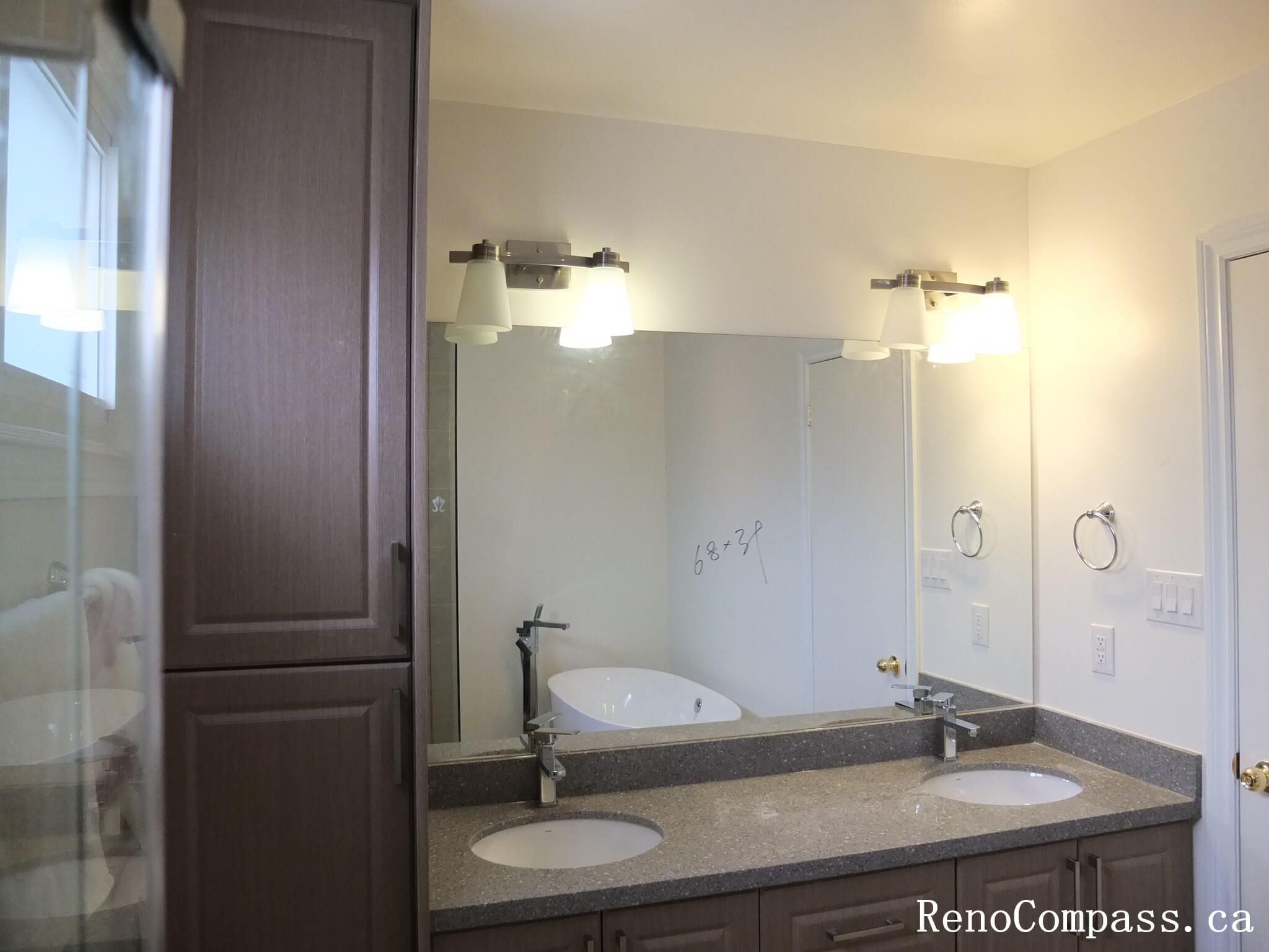 Bathroom renovation in North York featuring a double sink vanity, wall-mounted mirrors, quartz countertop, and integrated lighting. This Toronto interior renovation focuses on shared-use efficiency, balanced layout, and clean modern finishes suitable for family bathrooms.