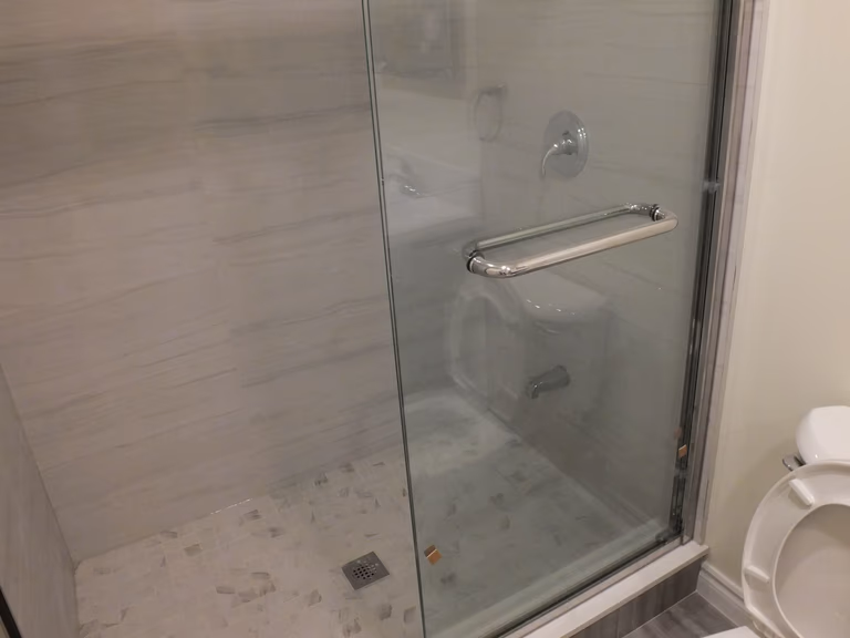 This Vaughan basement bathroom renovation features a sleek frameless glass shower enclosure designed for durability and modern aesthetics. Completed by a professional Toronto Renovation Company, the shower includes waterproof tile finishes, a secure glass door handle, and a clean linear layout that maximizes space and comfort. The contemporary design enhances brightness while maintaining easy maintenance and long-term functionality. This upgraded shower area adds both style and value to the finished basement bathroom, making it ideal for everyday use and guest convenience.