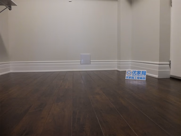 This Richmond Hill basement renovation features a spacious open-concept living area with dark hardwood flooring, recessed lighting, and bright basement windows. The natural light reflecting off the flooring enhances the sense of space, creating a warm and inviting environment ideal for family use or entertainment.