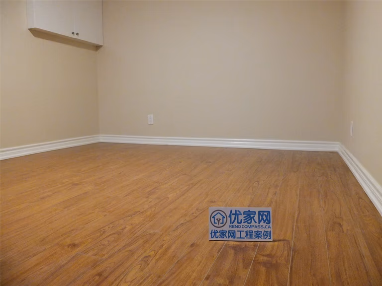 This Markham basement renovation project features newly finished walls, fresh interior painting, and durable laminate flooring installation. The clean wall finish, neutral paint tones, and wood-style flooring create a bright, comfortable living space suitable for a family recreation room or additional living area. Careful detailing around the baseboards and wall edges ensures a smooth and polished appearance throughout the basement interior.