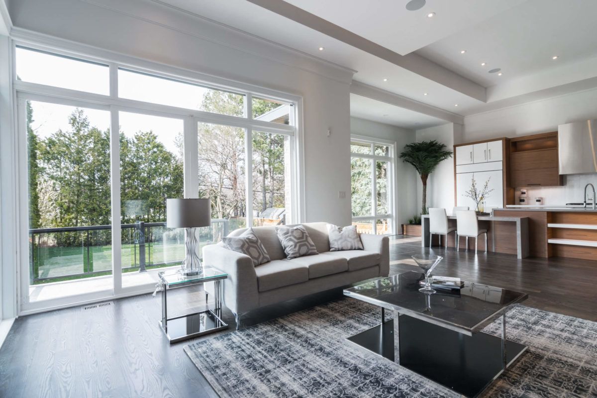 This expansive open-concept living and kitchen space is part of a 4,500 sq ft luxury home renovation in Toronto. Floor-to-ceiling windows flood the interior with natural light, enhancing the modern layout and seamless connection between living, dining, and kitchen areas. Dark hardwood flooring, clean architectural lines, and contemporary finishes create a refined yet welcoming atmosphere. Designed and built by a trusted Toronto Renovation Company, Reno Compass Inc., this project showcases premium craftsmanship and sophisticated residential living.