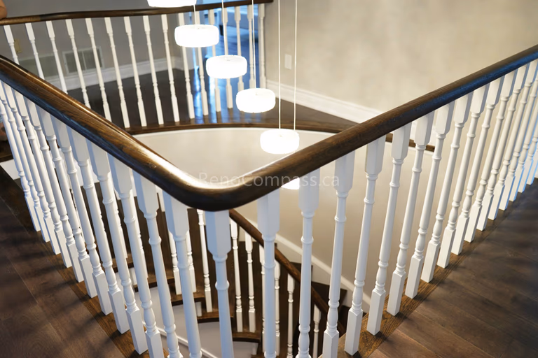 This North York interior renovation showcases a beautifully upgraded curved staircase featuring refinished hardwood steps, white spindles, and a smooth modern handrail. The elegant stair design enhances the entryway and adds architectural character while matching the warm hardwood flooring throughout the home. Completed by Reno Compass Inc., delivering professional interior renovation and staircase upgrade services across North York and the Greater Toronto Area.