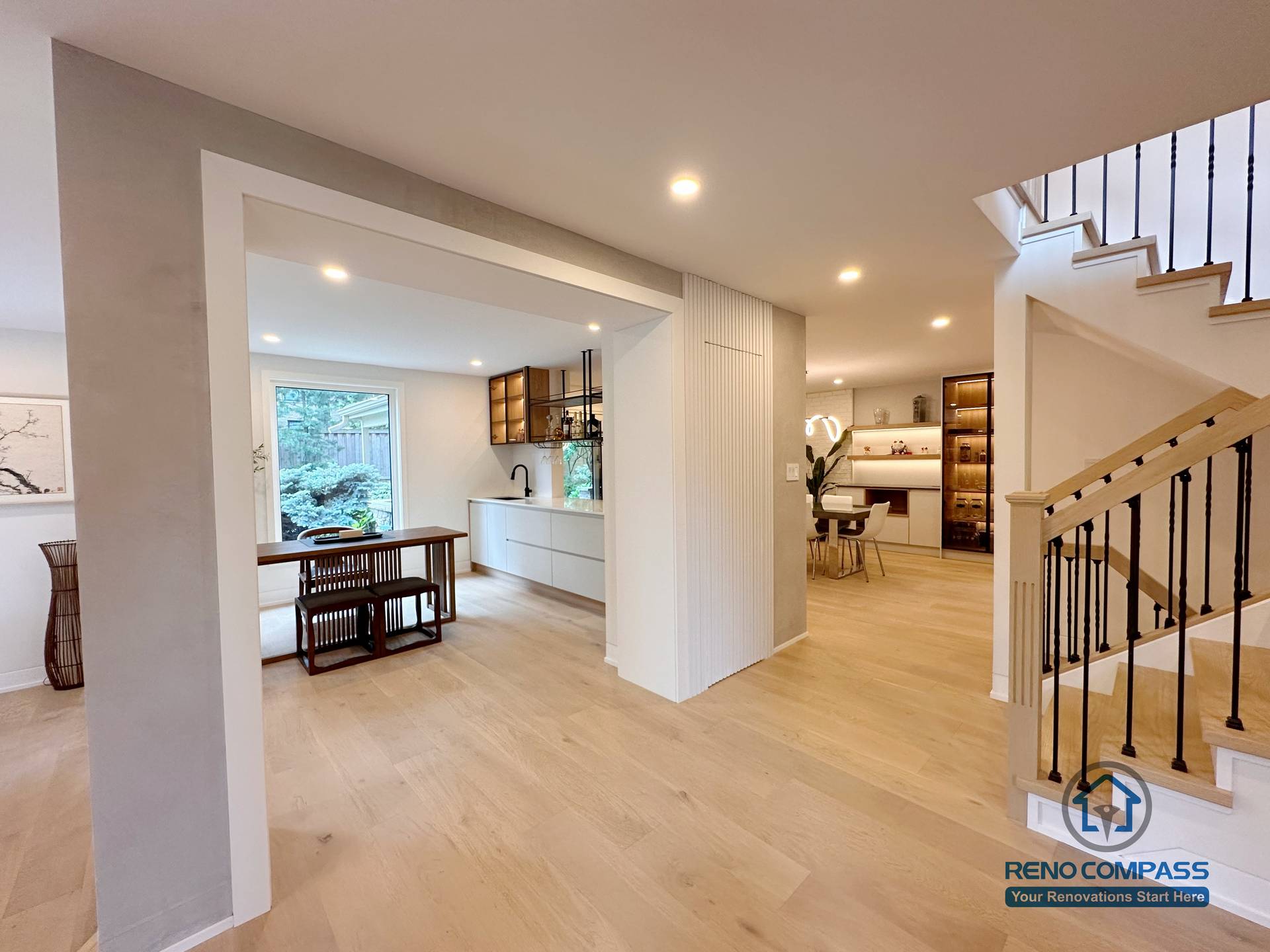 This Toronto flooring and stair renovation showcases a modern open-concept interior with light oak hardwood floors, custom staircase design, and seamless transitions between living, kitchen, and dining areas. The project highlights clean architectural lines, upgraded stair railings, and cohesive flooring installation that enhances natural light and spatial flow—ideal for contemporary home renovations in Toronto.