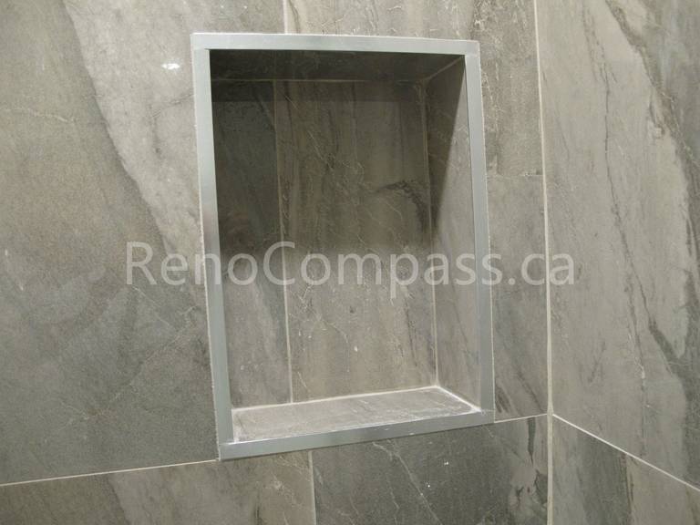 Built-in shower niche detail from a Markham basement renovation, finished with marble-look porcelain tiles and clean trim edges for a seamless storage solution. Completed by Reno Compass, this custom shower feature adds convenience, durability, and modern design to the upgraded basement bathroom.