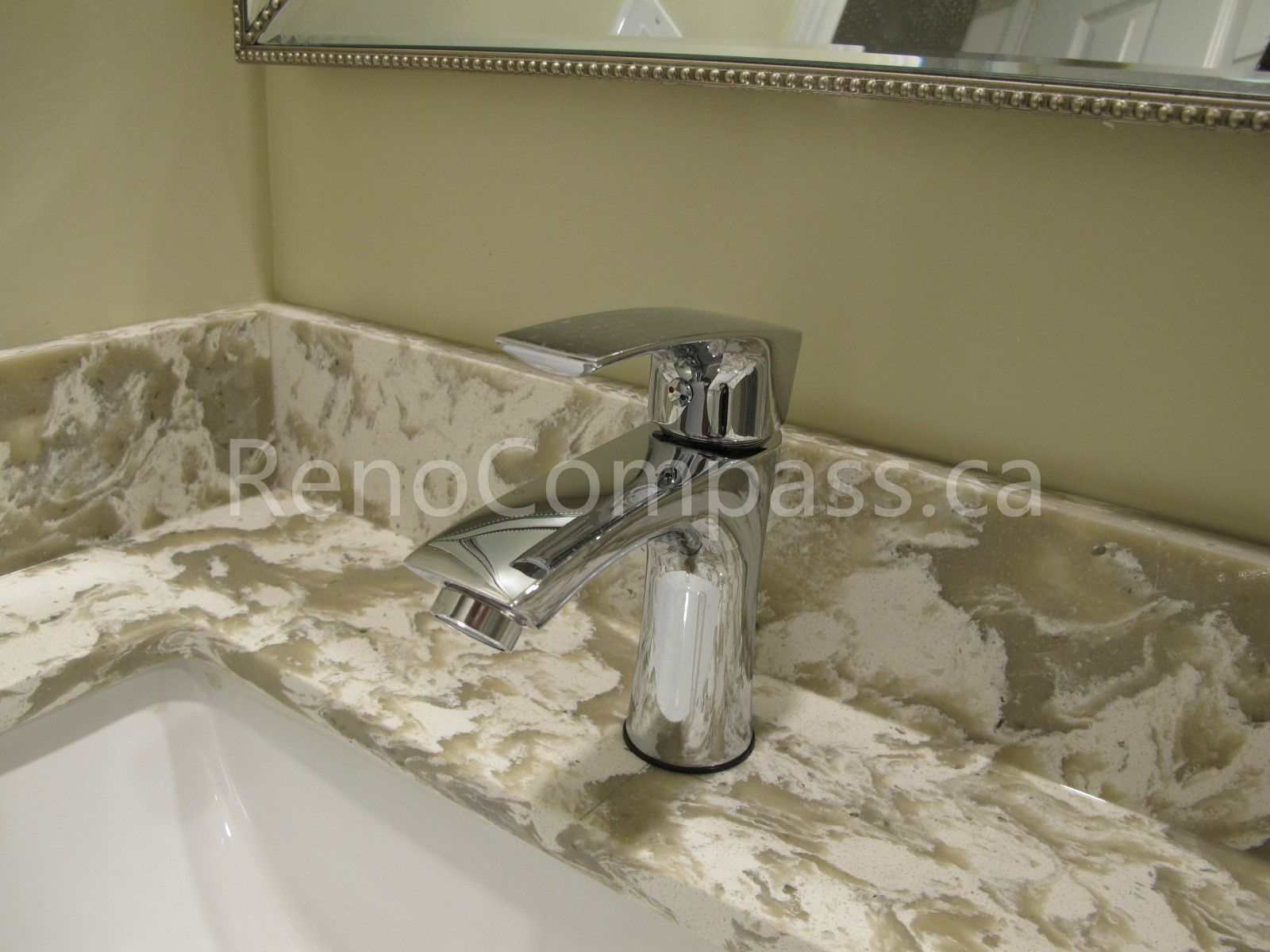 Modern bathroom vanity detail from a Markham basement renovation featuring a polished chrome faucet and elegant marble-look countertop. Completed by Reno Compass, this basement bathroom upgrade combines functionality, refined finishes, and contemporary design for a stylish and practical living space.