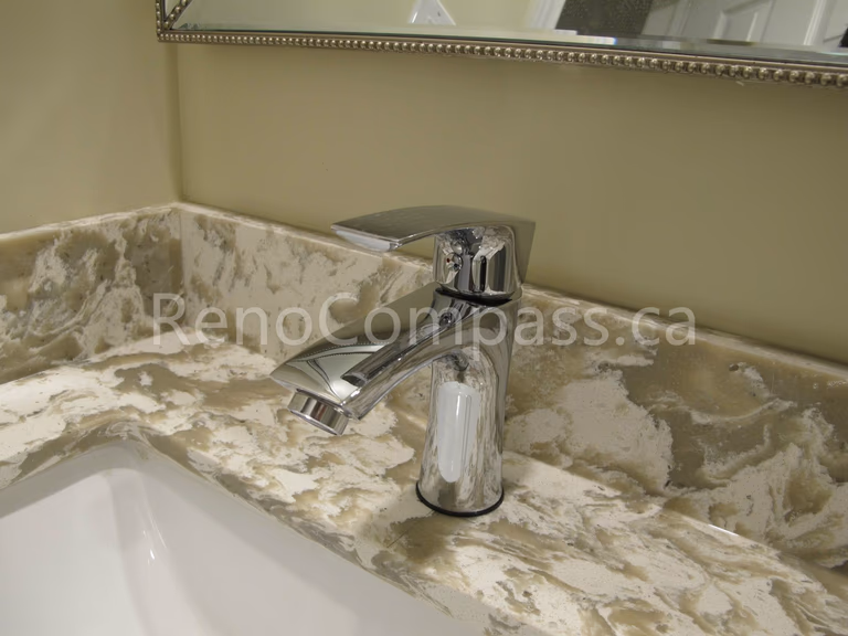 Modern bathroom vanity detail from a Markham basement renovation featuring a polished chrome faucet and elegant marble-look countertop. Completed by Reno Compass, this basement bathroom upgrade combines functionality, refined finishes, and contemporary design for a stylish and practical living space.