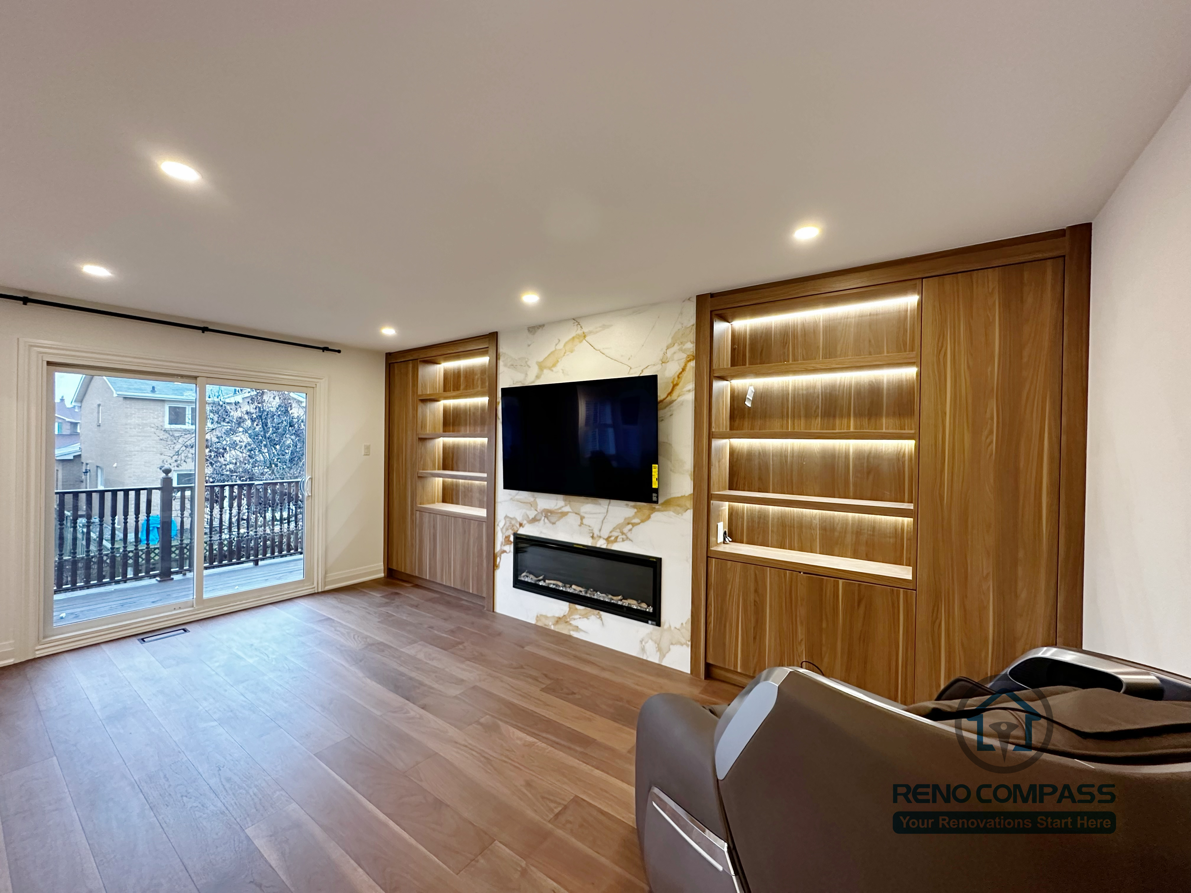 This Markham interior renovation features a custom-designed TV feature wall with integrated wood shelving and warm LED accent lighting. The combination of natural wood finishes, marble-pattern backdrop, and clean built-in cabinetry creates a balanced focal point for the living space. Floor-to-ceiling storage enhances both functionality and visual order, while the open layout maintains a bright and modern atmosphere. Completed by a professional Toronto renovation company, this project highlights precise craftsmanship, material coordination, and long-term design durability.