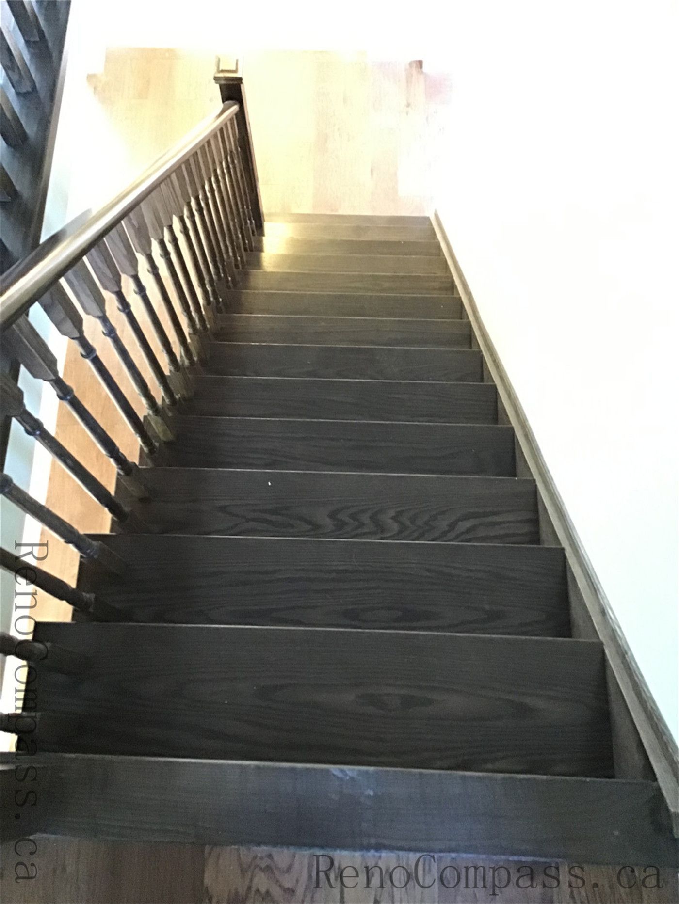 This image highlights a staircase renovation in Richmond Hill featuring dark wood stair treads paired with a modern railing system. The contrast between deep tones and clean lines enhances the overall interior aesthetic while ensuring durability and safety.