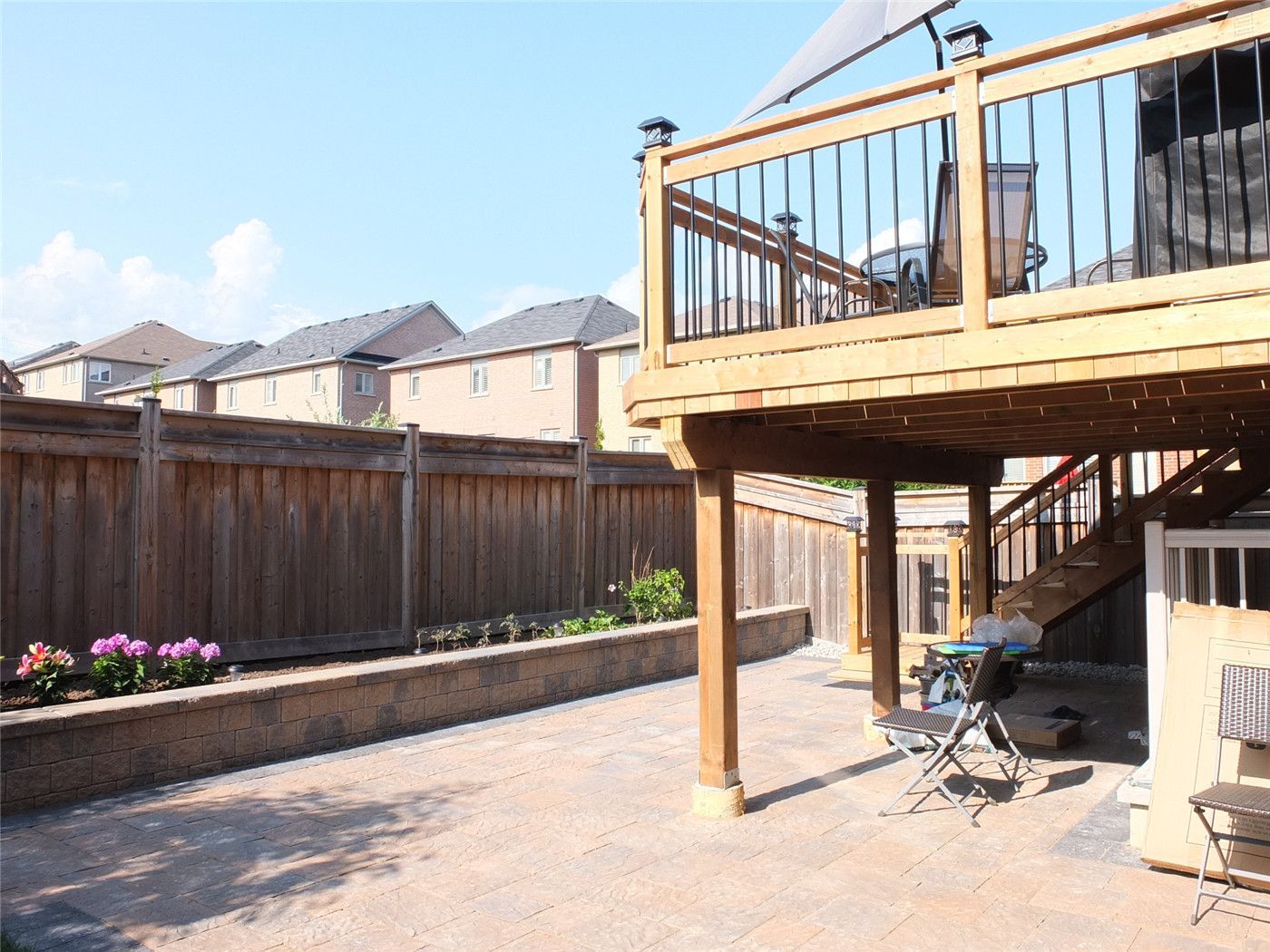 This Toronto backyard landscaping renovation showcases a custom elevated wood deck paired with a spacious interlocking stone patio, creating a functional and stylish outdoor living space. The project features durable pressure-treated wood construction, modern black railing accents, and a professionally installed interlocking base for long-term stability and drainage. Designed for relaxation and entertaining, this backyard upgrade enhances property value while delivering a clean, low-maintenance outdoor environment by an experienced Toronto renovation and landscaping team.
