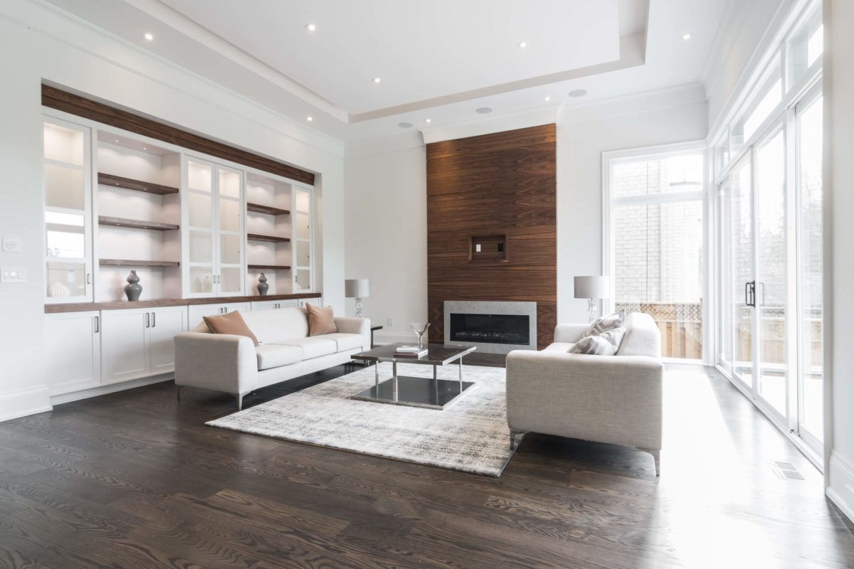 This refined living room is part of a 4,500 sq ft luxury home renovation in Toronto, featuring custom built-in display cabinetry, a modern fireplace feature wall, and expansive floor-to-ceiling windows. The open layout and rich hardwood flooring create a sophisticated yet comfortable environment for modern family living. Completed by a trusted Toronto Renovation Company, Reno Compass Inc., this project highlights high-end craftsmanship, elegant detailing, and thoughtfully designed residential interiors.