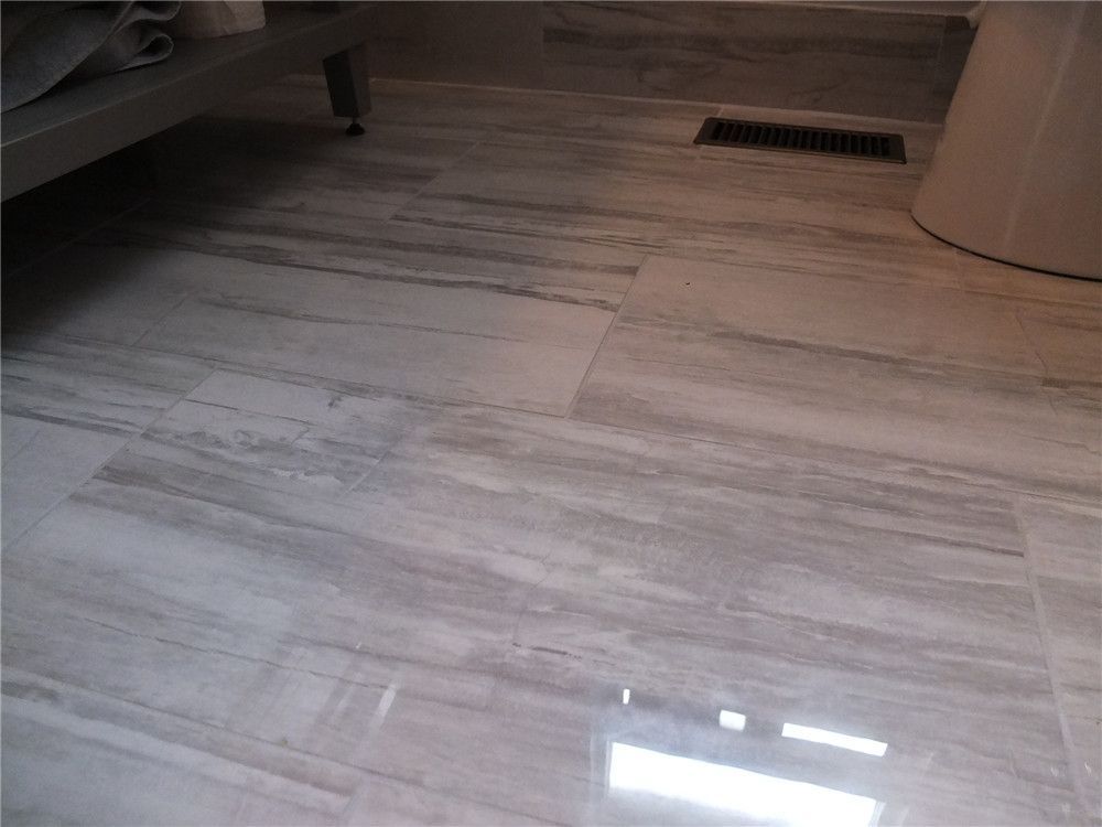 This North York bathroom renovation features modern wood-look porcelain tile flooring designed for durability and moisture resistance. The large-format tiles create a clean, seamless appearance while enhancing the overall brightness and visual space of the bathroom. As part of a professional Toronto renovation project, the upgraded flooring improves both functionality and contemporary design, providing a long-lasting and easy-maintenance bathroom surface.