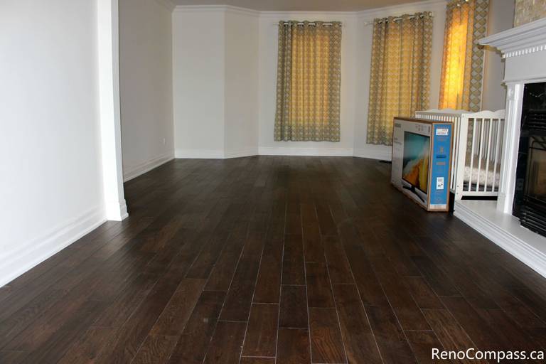 This Mississauga interior renovation showcases a spacious living area upgraded with premium dark hardwood flooring, fresh modern wall finishes, and enhanced natural lighting through large windows with custom curtains. The renovation improves comfort, durability, and overall home value while creating a warm and elegant living space. Completed by a professional Toronto renovation company, Reno Compass Inc., this project highlights quality craftsmanship and refined interior finishing.