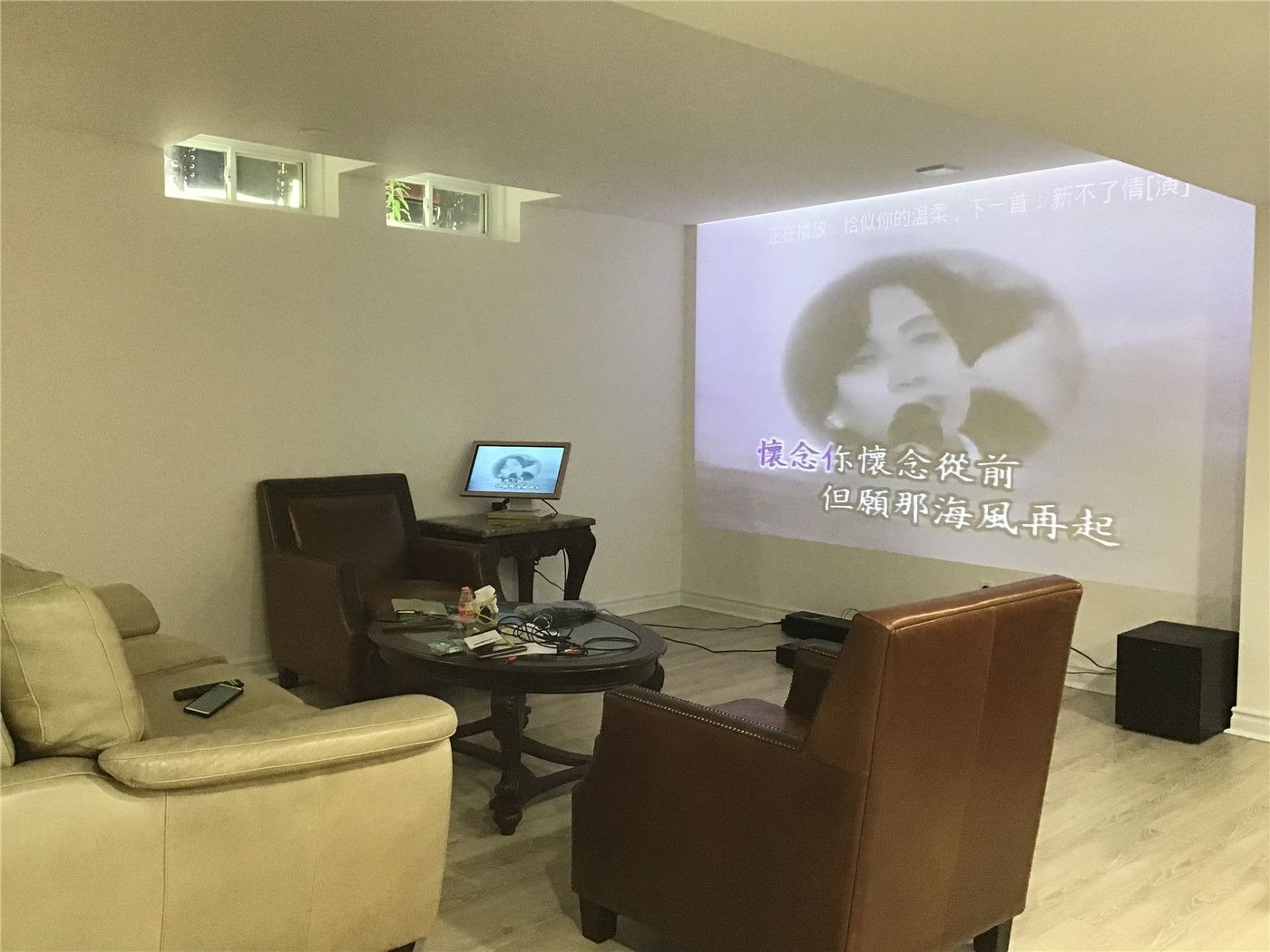 This Aurora basement renovation highlights a cozy home theater setup with a projector screen, comfortable seating, and a relaxed lounge atmosphere. The space is designed for entertainment and everyday living, featuring warm lighting, soft-toned flooring, and an inviting open layout.