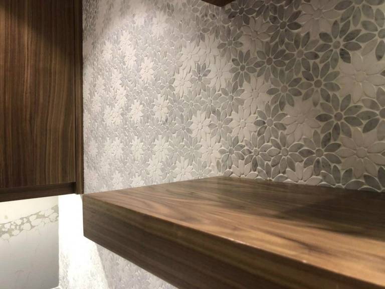 Elegant Markham home renovation featuring a custom floating wood shelf, textured floral feature wall, and warm wood panel detailing. This modern interior upgrade combines functional storage with refined design, creating a cozy and sophisticated living space for contemporary homes in Markham.