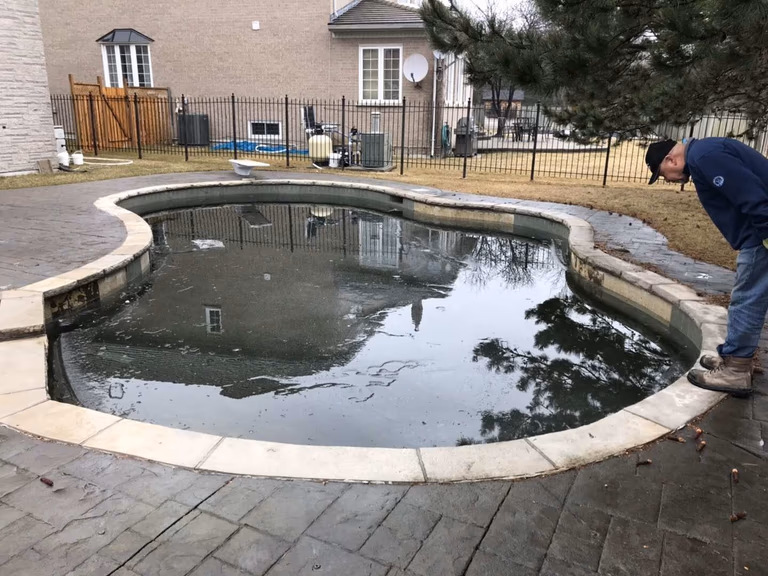 Professional swimming pool renovation project in Toronto. Our team inspects and cleans a residential backyard pool to prepare for resurfacing and improved water quality. Expert maintenance and remodeling for luxury outdoor spaces.