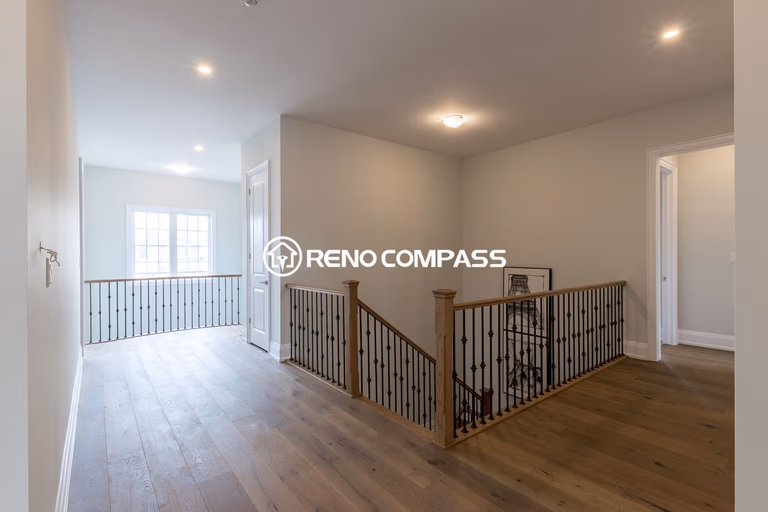 This image shows an upper floor area in a Newmarket home renovation project, featuring professionally installed engineered wood flooring and modern stair railings. The flooring provides a natural hardwood appearance with improved stability and durability. The project was completed by Reno Compass Inc., a Toronto renovation company specializing in flooring and interior renovations.