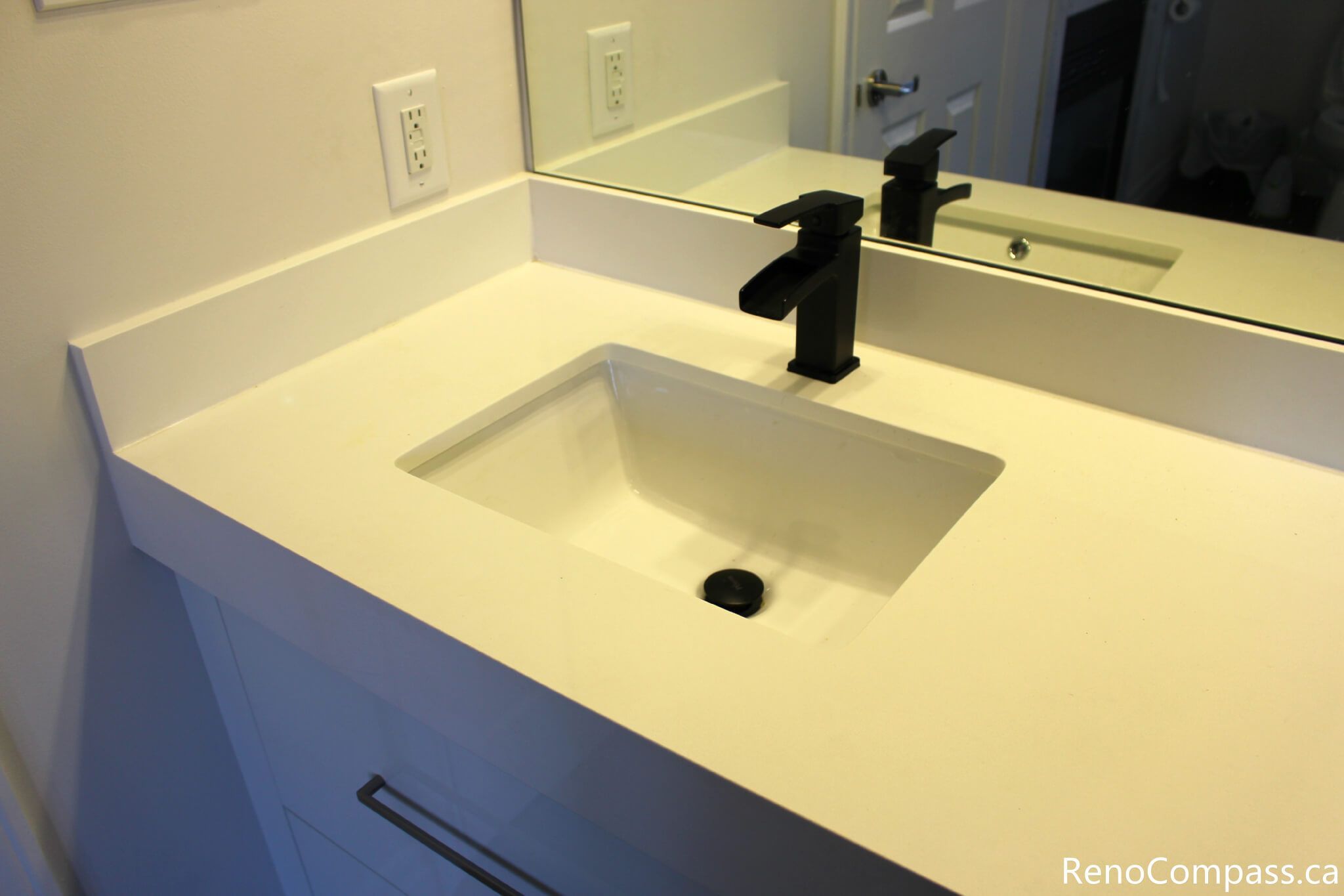 This Mississauga bathroom renovation showcases a sleek quartz vanity countertop with an integrated undermount sink and a matte black single-handle faucet. The clean lines, durable surface, and minimalist hardware create a modern, low-maintenance bathroom design that balances style and everyday functionality.