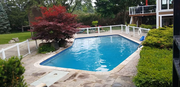 After renovation photo of a fully restored backyard swimming pool in Toronto. The new bright blue liner, clean water, and resurfaced edges highlight the professional pool transformation from old and damaged to modern and inviting. Expert pool renovation by local Toronto specialists.