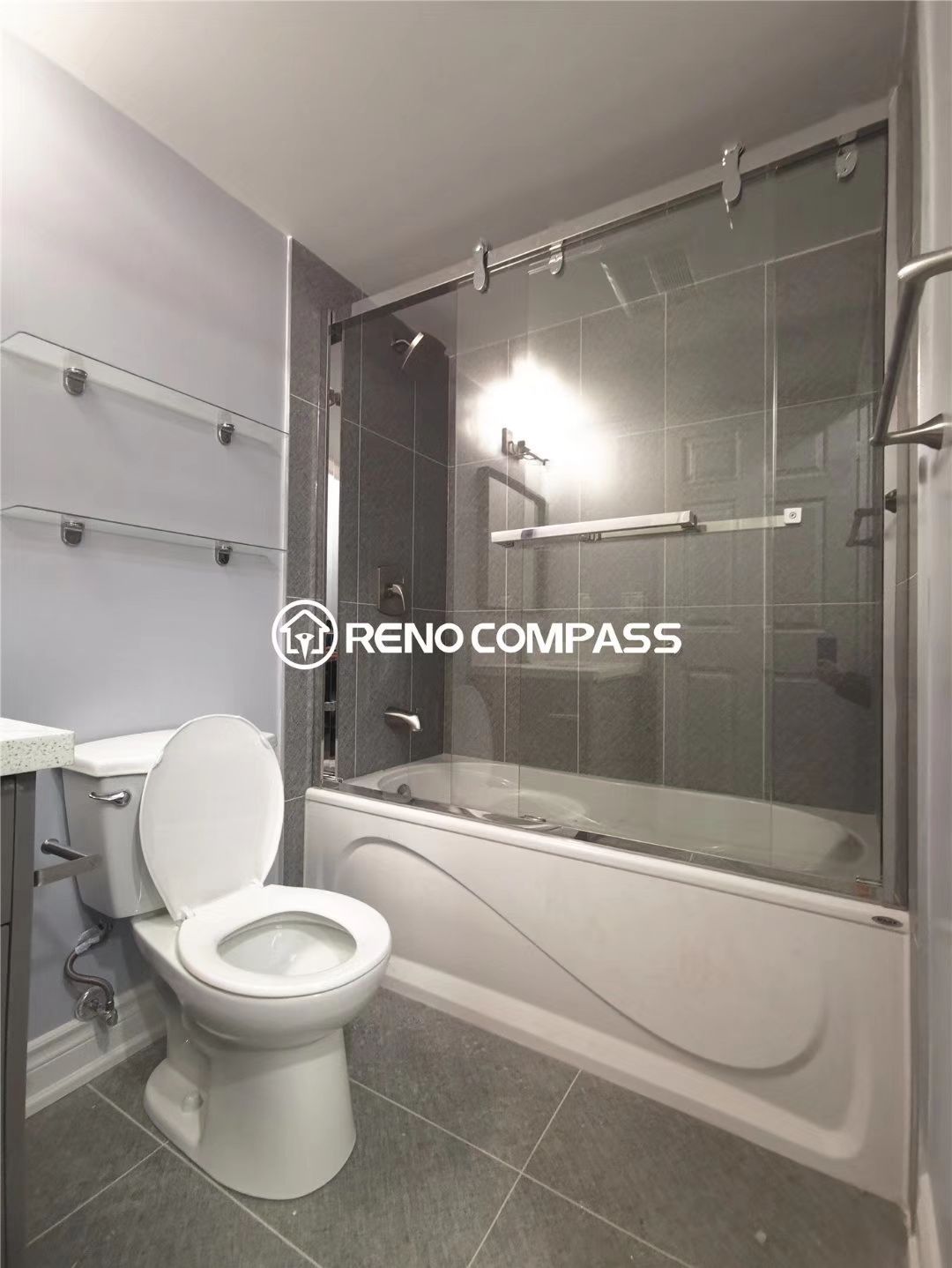 This Richmond Hill condo bathroom renovation showcases a clean and modern upgrade featuring a new bathtub with sliding glass shower doors, updated grey wall tiles, modern flooring, and improved lighting. The layout was optimized to enhance comfort and usability while maintaining a sleek and minimalist condo style. Completed by Reno Compass, a trusted Toronto renovation company, this project highlights practical bathroom remodeling solutions designed for condominium living, combining durability, functionality, and contemporary design for everyday comfort.