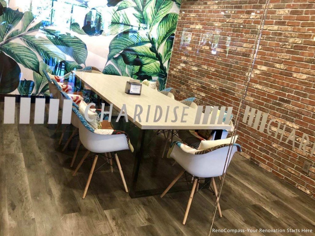 This Barrie commercial renovation features a stylish dining and meeting area with custom furniture, wood-look flooring, and decorative feature walls combining brick and tropical design elements. The inviting layout enhances customer comfort and social interaction within the bubble tea shop. Completed by Reno Compass Inc., a professional Toronto renovation company, this project reflects modern commercial interior design tailored for cafés, dessert shops, and retail spaces across Barrie and the GTA.