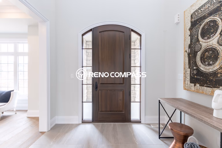 This image shows a bright and modern home entrance after a Newmarket flooring renovation project in Toronto. The homeowner selected engineered wood flooring, which provides the natural appearance and comfortable feel of solid hardwood while offering greater structural stability. Engineered wood floors are constructed with multiple layers of wood pressed together in a cross-grain structure, helping prevent expansion, cracking, and warping. This flooring upgrade enhances durability, improves moisture resistance, and creates a clean, elegant entry space for the home. Renovation completed by Reno Compass Inc., a Toronto renovation company specializing in flooring installation and interior upgrades.