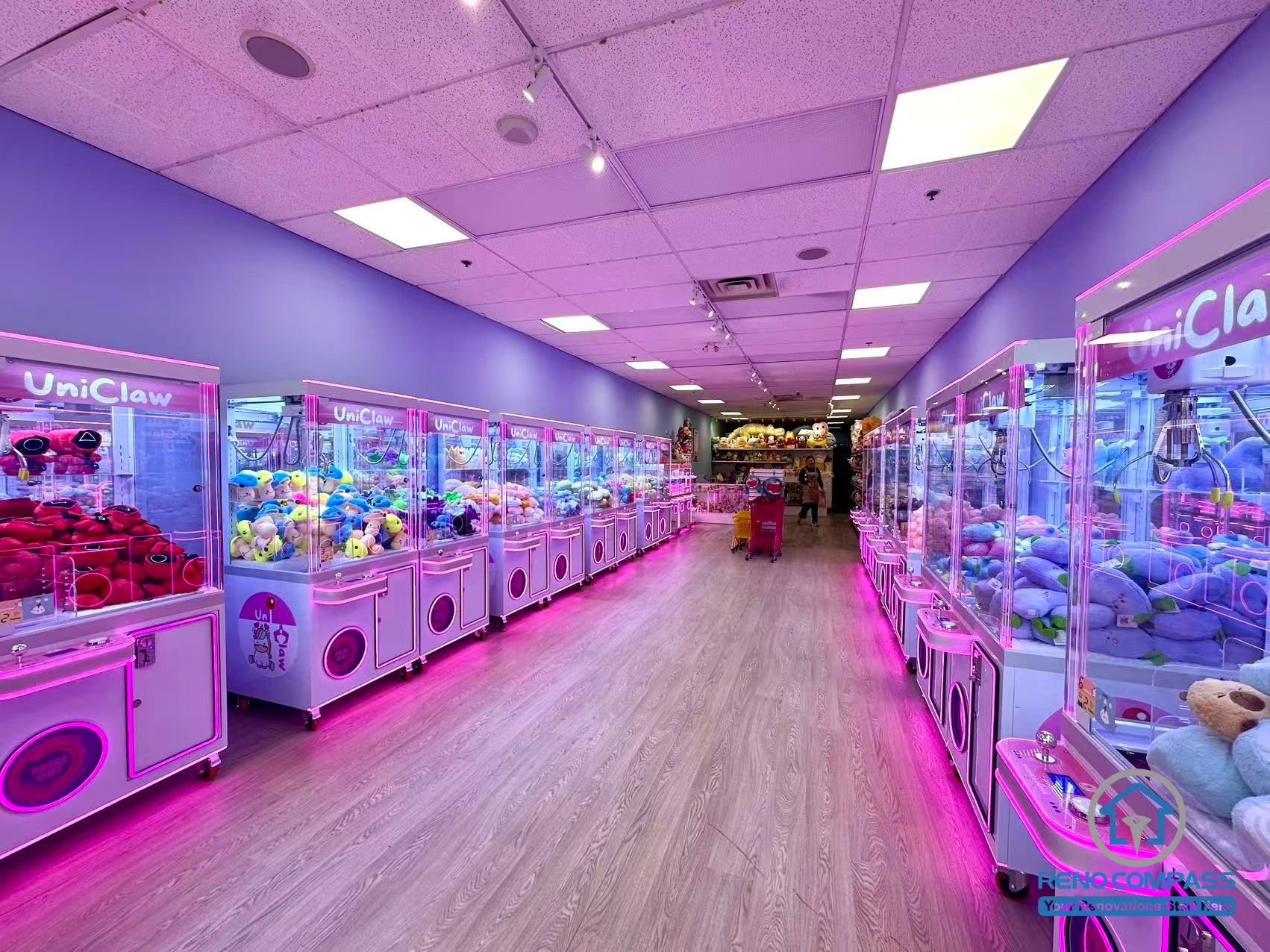 Interior layout of an arcade claw machine and game store located inside Oakville Place Mall. The design features a central walkway with claw machines arranged on both sides, creating an engaging indoor entertainment space similar to a compact indoor playground.