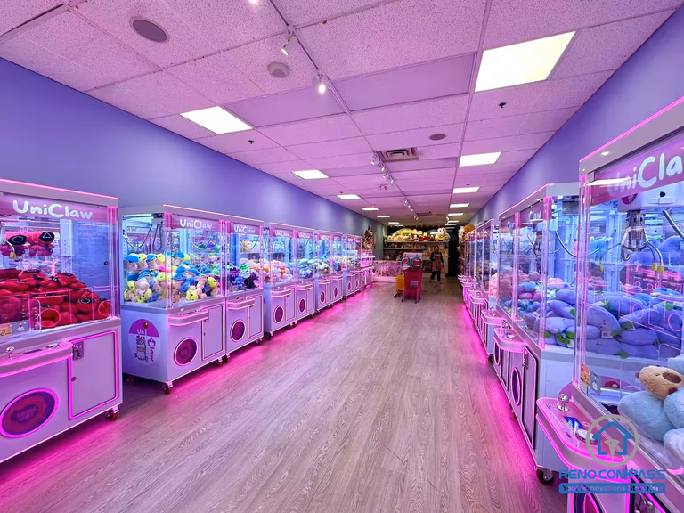 Interior layout of an arcade claw machine and game store located inside Oakville Place Mall. The design features a central walkway with claw machines arranged on both sides, creating an engaging indoor entertainment space similar to a compact indoor playground.