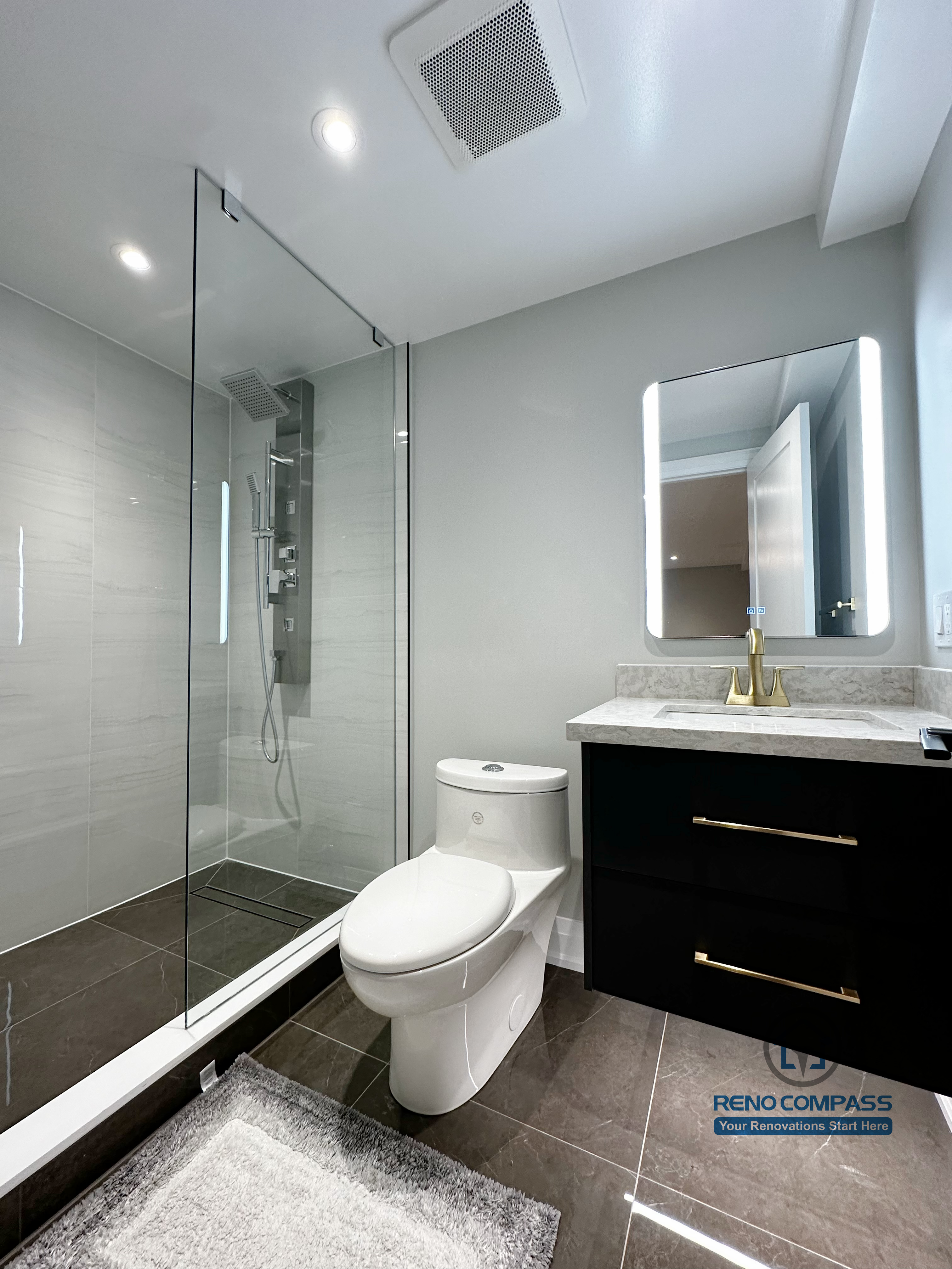 Basement bathroom renovation in Richmond Hill featuring a glass walk-in shower, modern vanity with quartz countertop, LED mirror, and sleek fixtures for a clean, contemporary look.