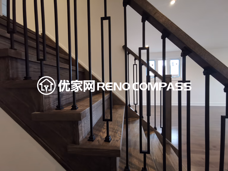 This image highlights a modern staircase completed as part of a North York interior renovation project. The staircase features natural wood treads paired with sleek black metal railings, creating a clean and contemporary contrast. The minimalist railing design enhances visual openness while maintaining safety and durability. Seamlessly integrated with the surrounding hardwood flooring, this staircase design reflects precise craftsmanship and thoughtful material selection, adding both architectural character and functional value to the overall interior renovation.